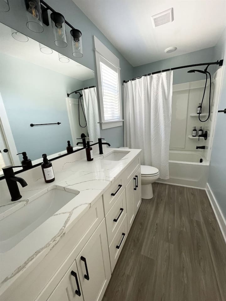 Bright and modern full bathroom with tub/shower combo for guest convenience.