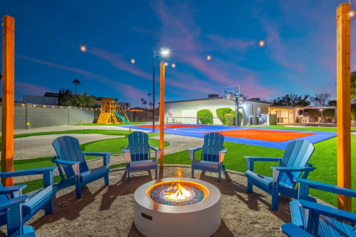 Evening falls and the fire pit lights up, with Adirondack chairs circled up for s'mores and storytelling. Just past the flames, a full sport court and play structure keep the fun going long after the sun sets.
