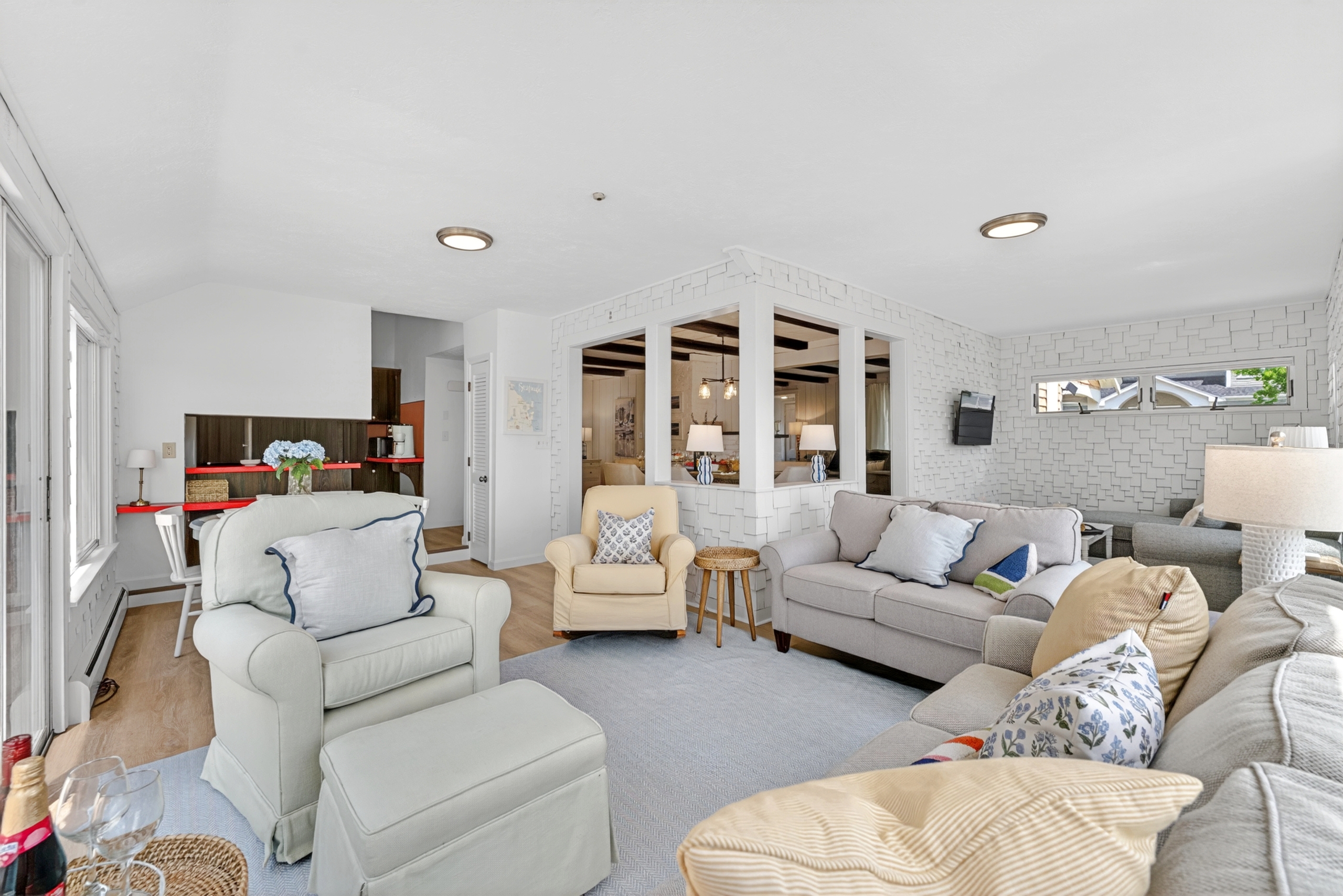 Spacious living room with large windows that bring in plenty of sunlight, highlighting a comfortable lounge space perfect for relaxing or gathering.