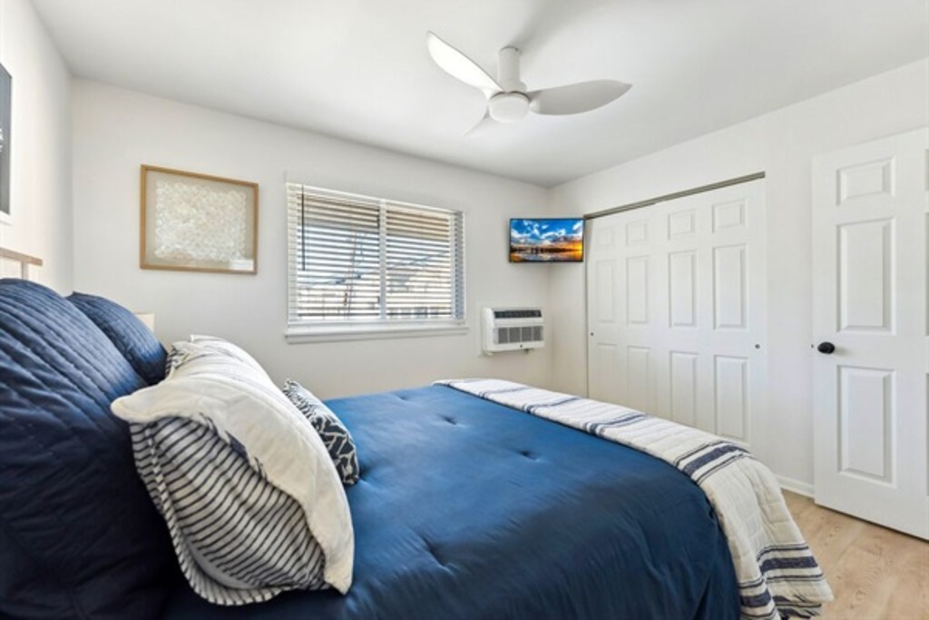 Comfortable queen room with a TV and window for fresh air.