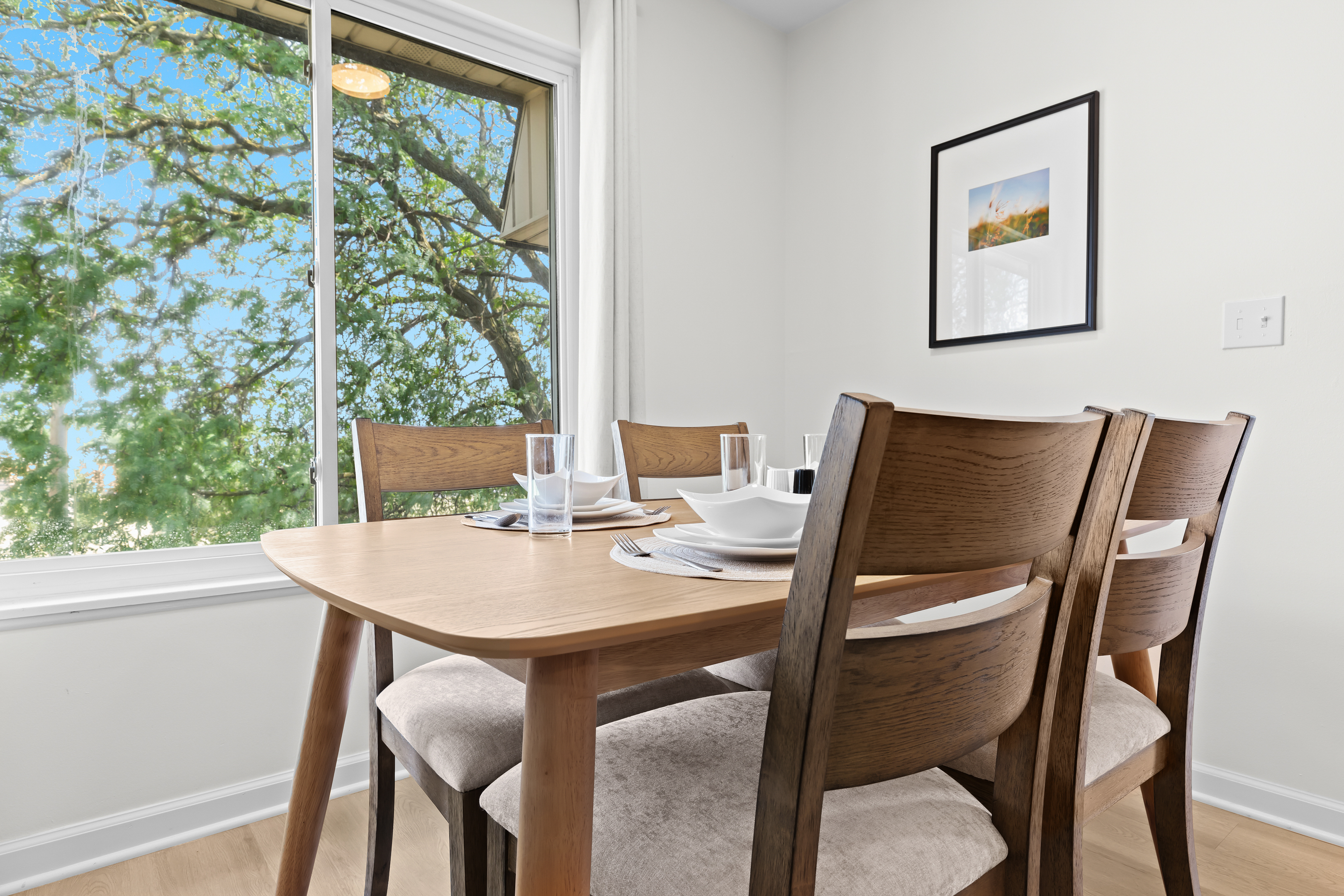 Cozy dining table set for four with a bright, scenic view.