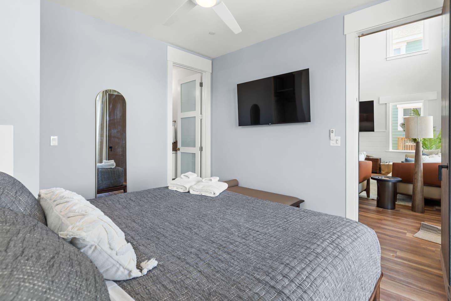 This bedroom features a full length mirror, 55-inch smart TV, brand new luxurious linens, and a wardrobe for clothing and luggage. 