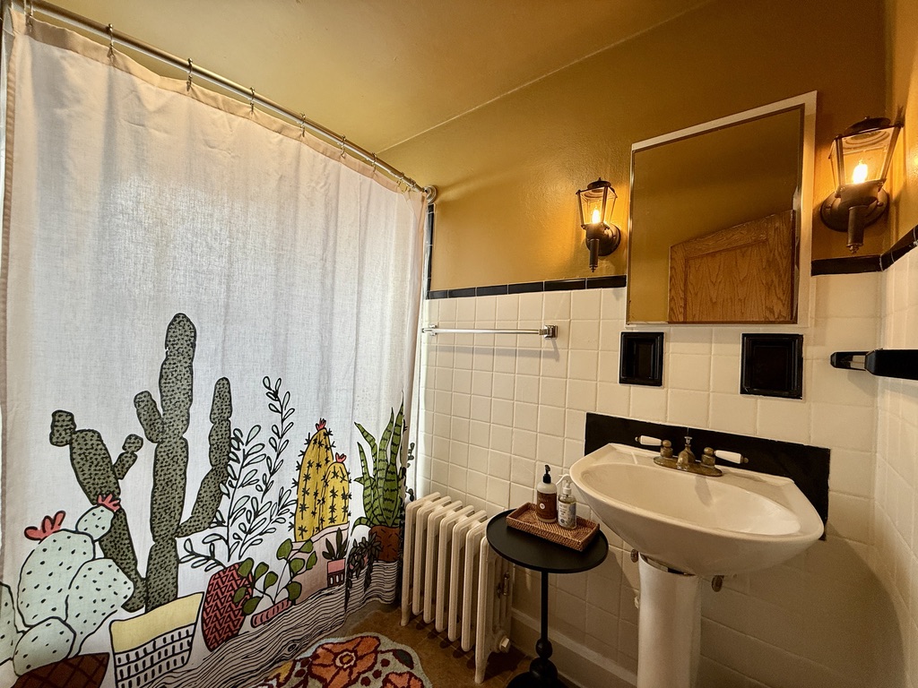 Full Bathroom with unique lighting and deep medicine cabinet.