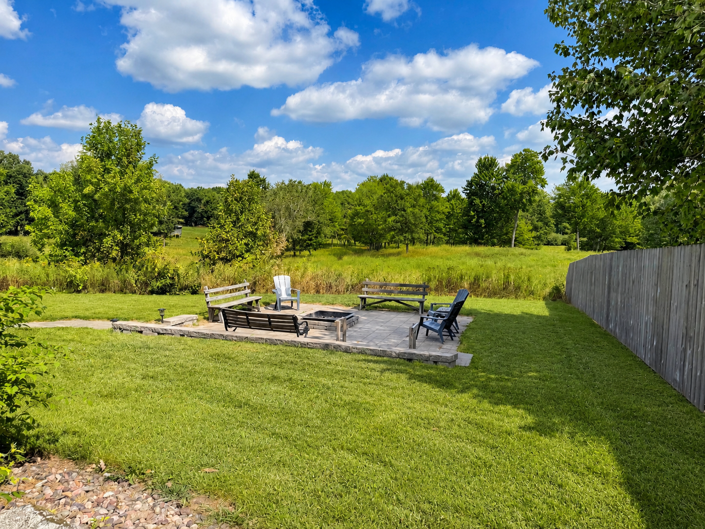Spacious backyard with patio seating and an outdoor fire pit, perfect for evening bonfires, conversations, and relaxing together beneath the Northwoods sky after a day of outdoor adventure.