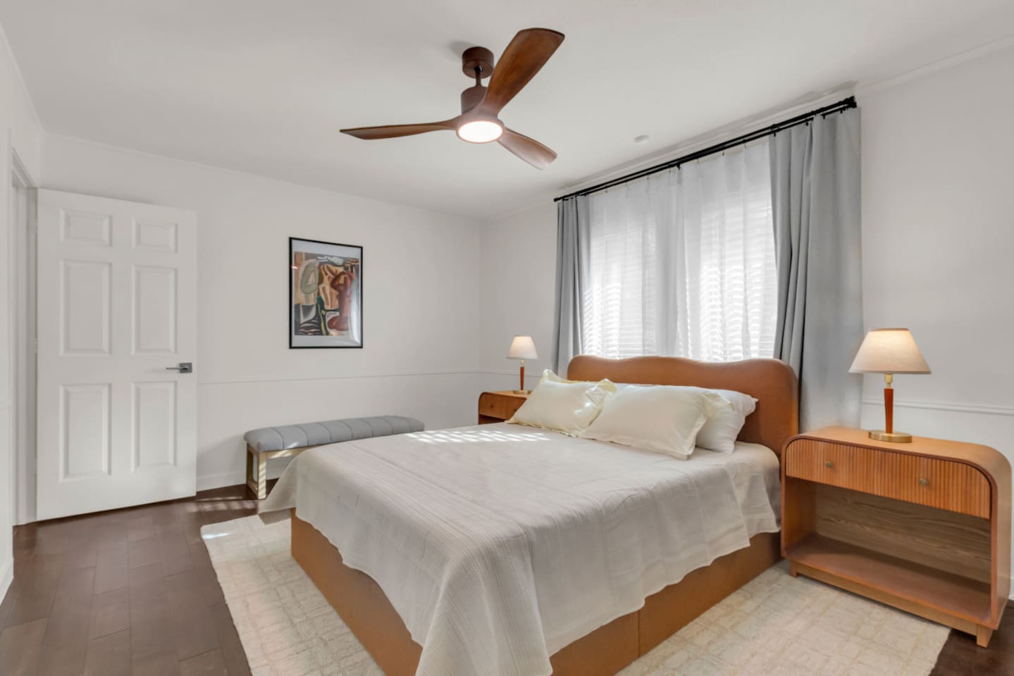 Guest bedroom with a queen bed, nightstands and lamps on each side, and a bench for added comfort and functionality.