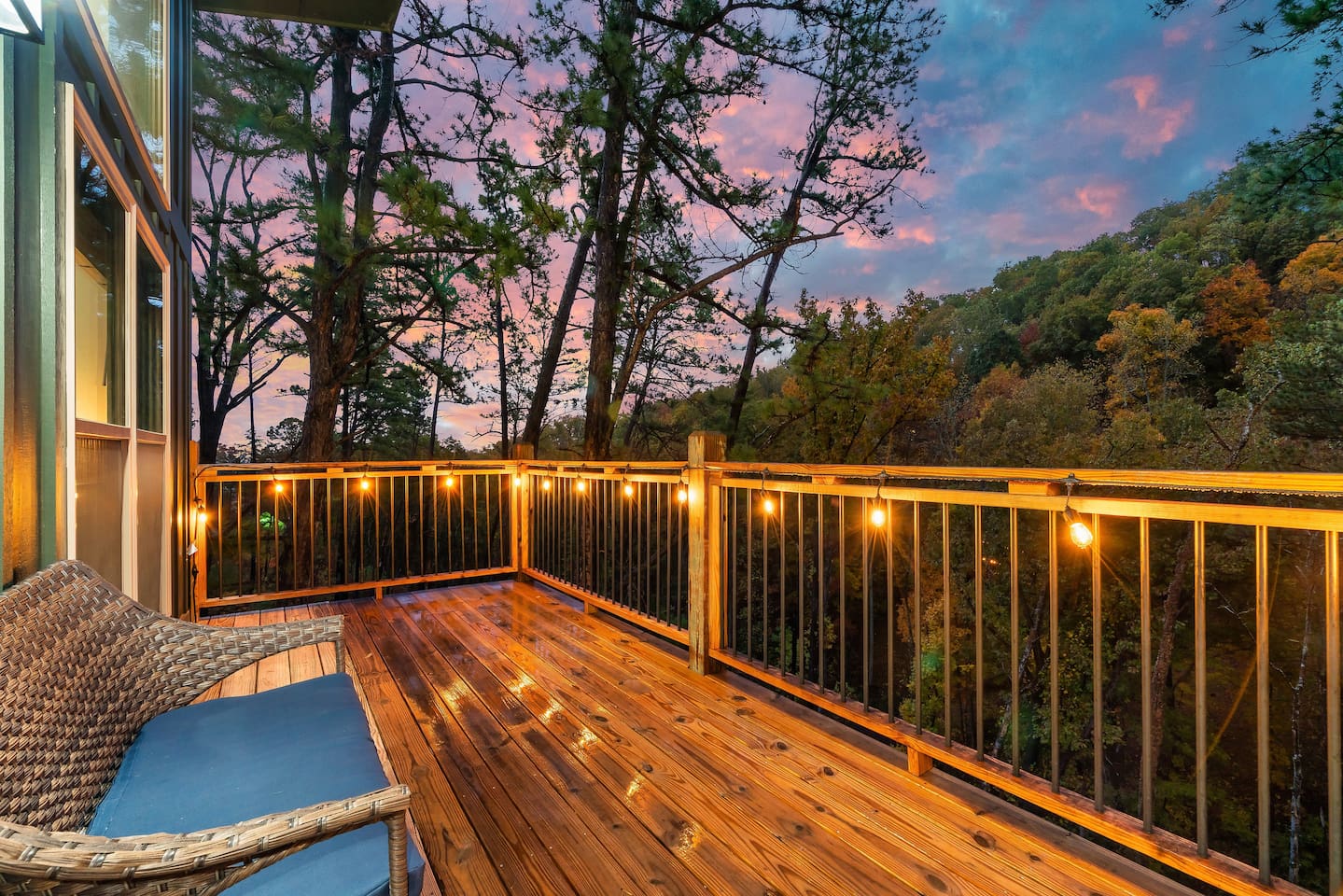 Private deck with glowing string lights and mountain views.