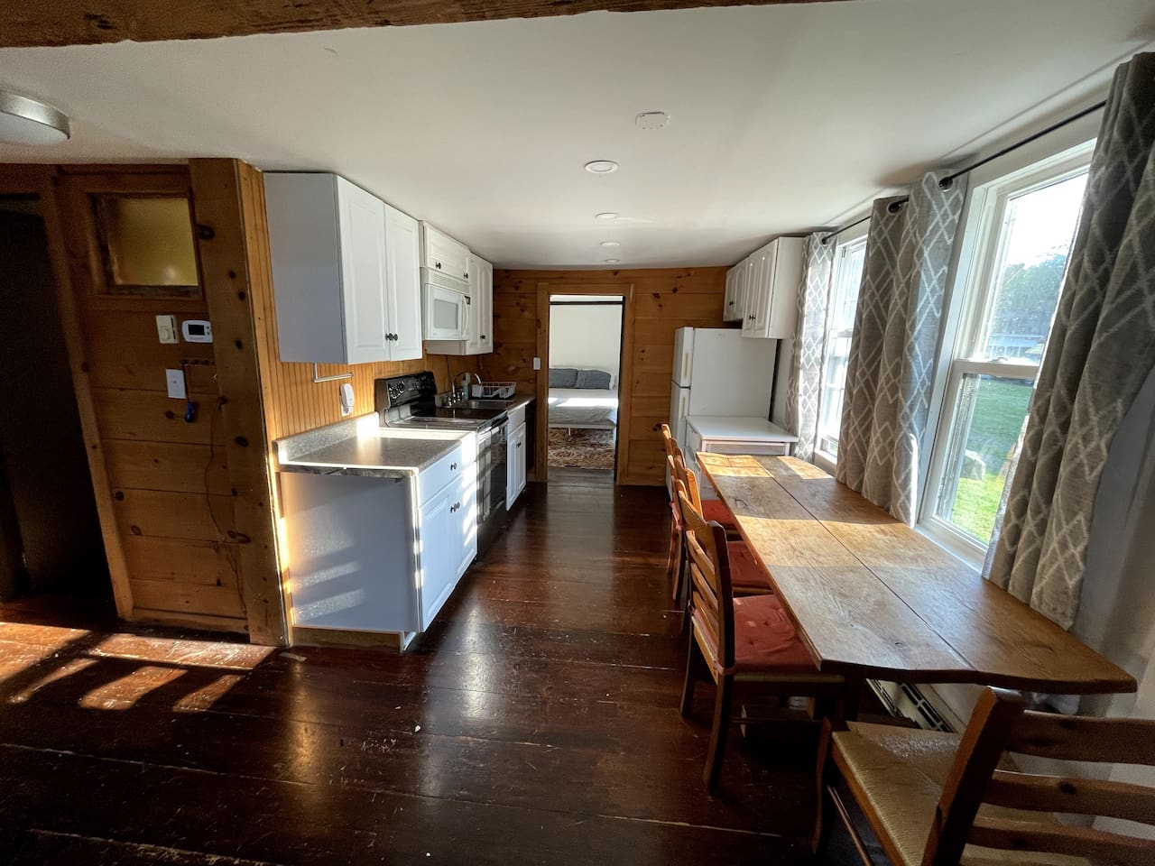 Kitchen seen from living room. Door from kitchen opens to bedroom with queen bed.
