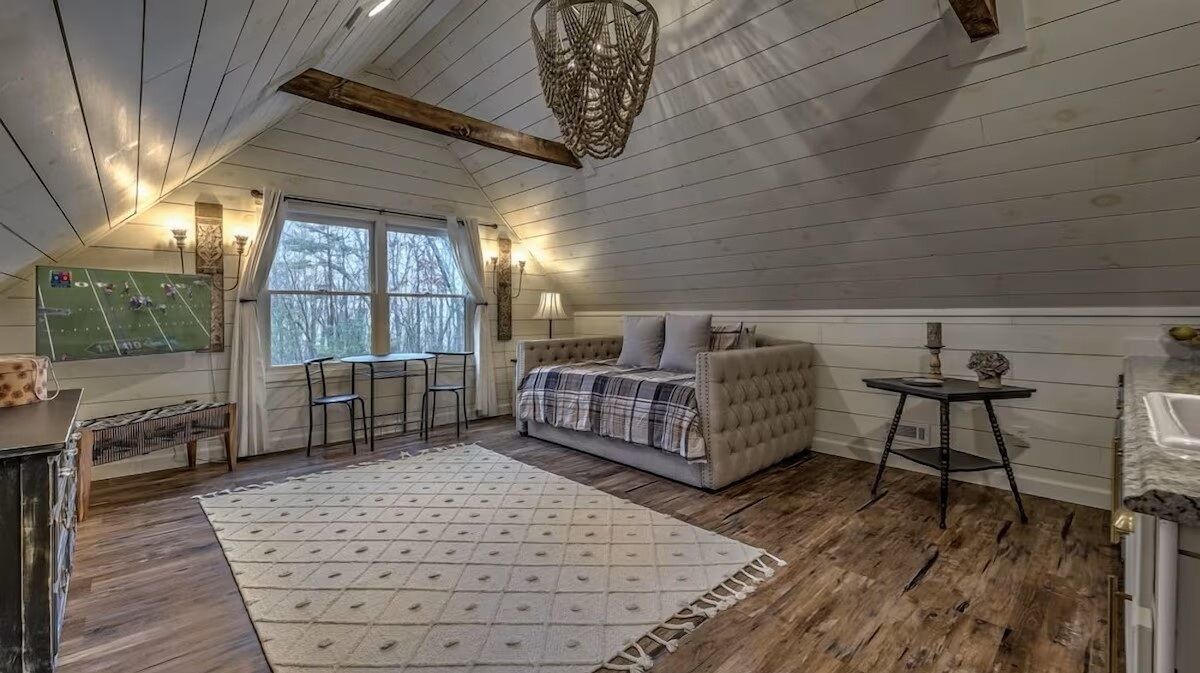 Detached guest suite above the garage with vaulted ceilings, comfortable seating, and a bright, open layout.