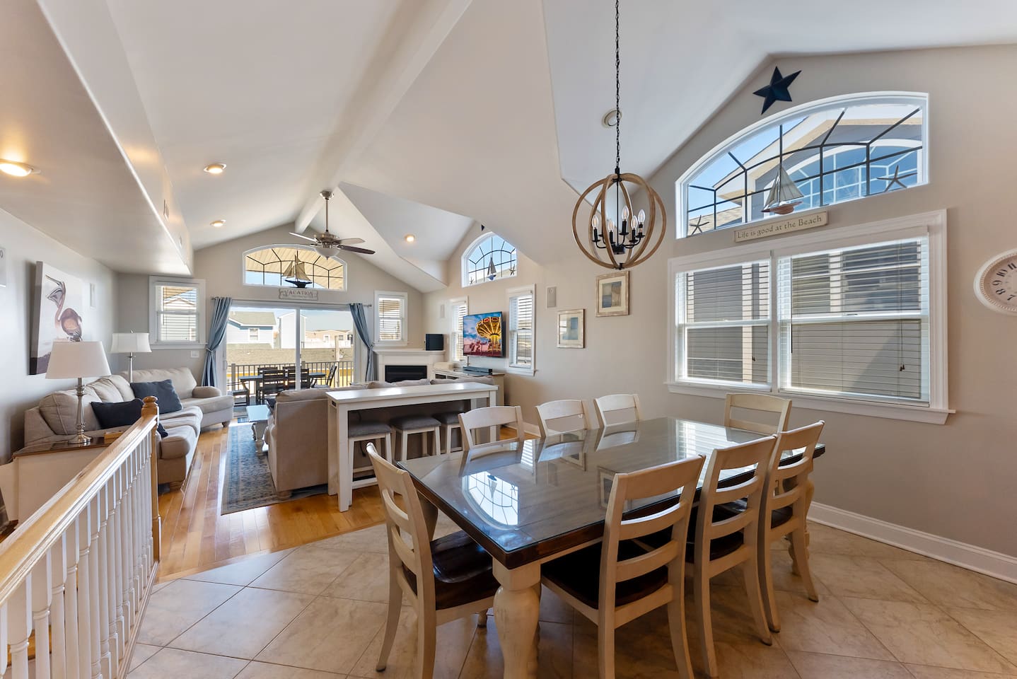 Spacious and bright open concept dining area with main dining table for 8, bar with 3 additional stools inside of the beautiful eat-in kitchen. 
