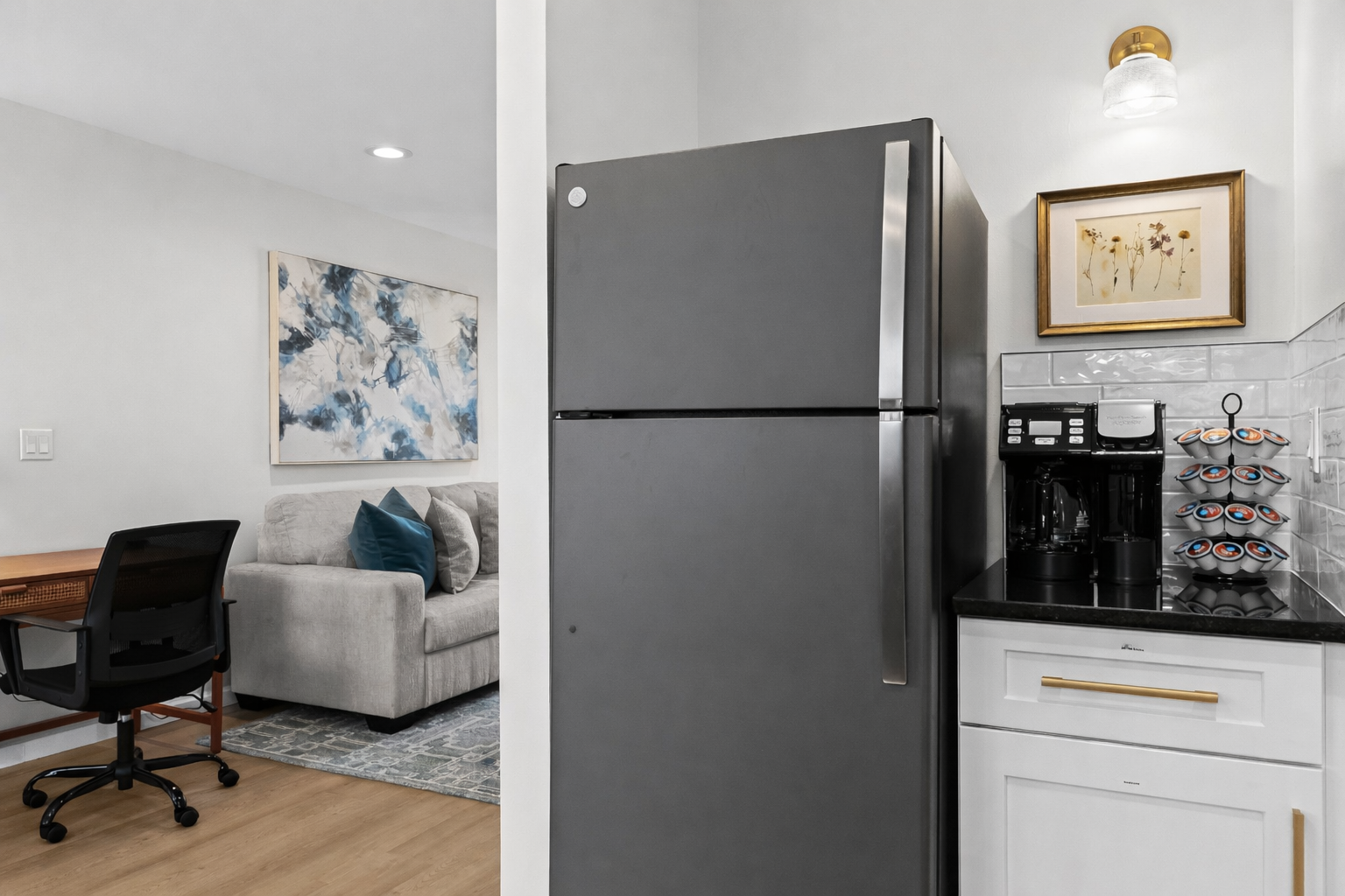 Modern kitchen with full-size fridge, sleek cabinetry, and a convenient coffee station—perfect for easy meals, morning brews, and longer stays.