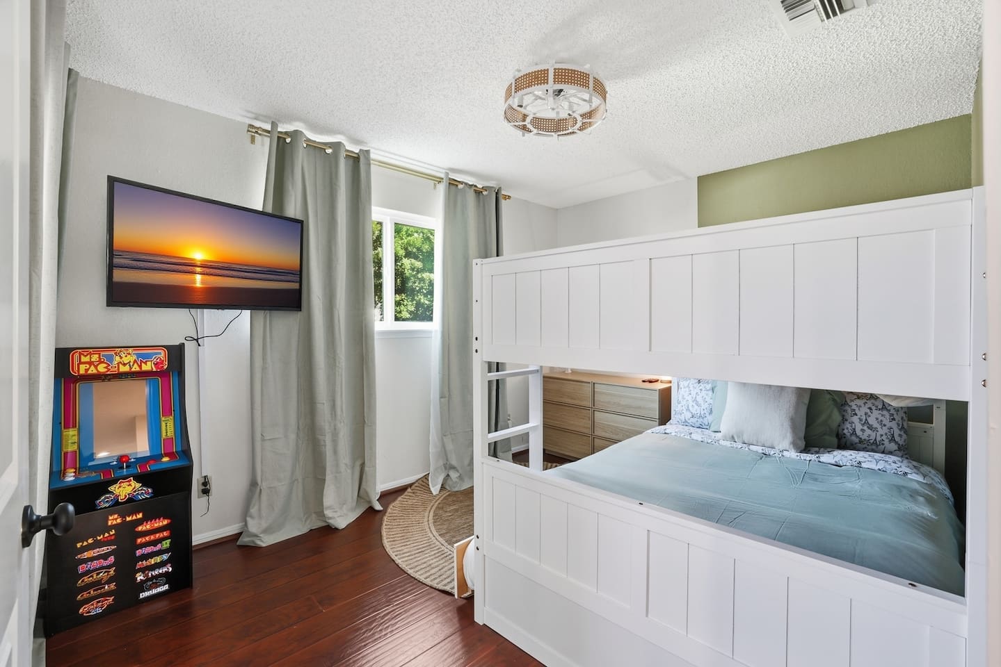 Spacious full-over-full bunk bed with twin trundle (lower bed suitable for toddlers). In-room TV and classic arcade game for entertainment. Includes dresser and closet space for easy storage. Changing pad available upon request. 