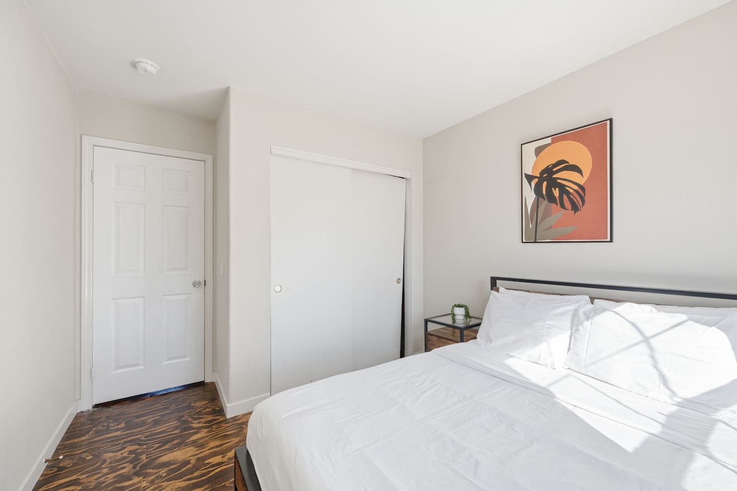 Queen bed with closet storage and room-darkening window treatments. Comfortable private sleeping space for couples or solo travelers.