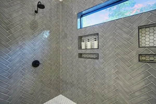 Modern walk-in shower with elegant tile work and built-in niches.