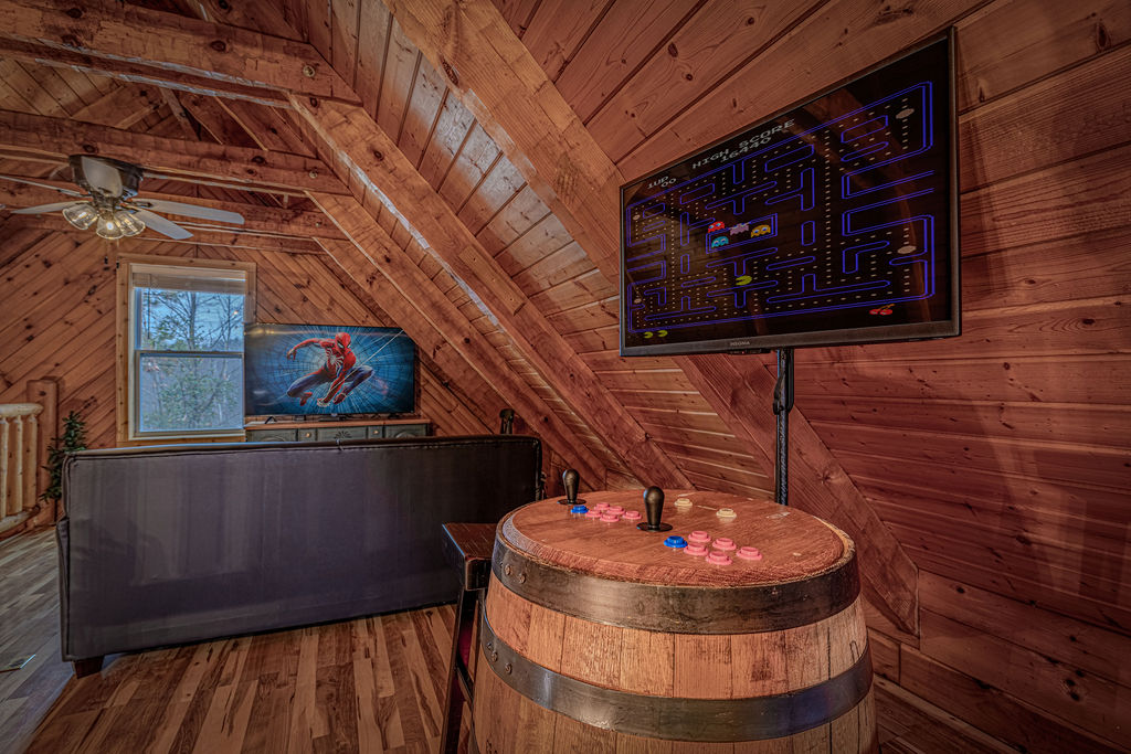 Loft hangout spot with a flatscreen and arcade
