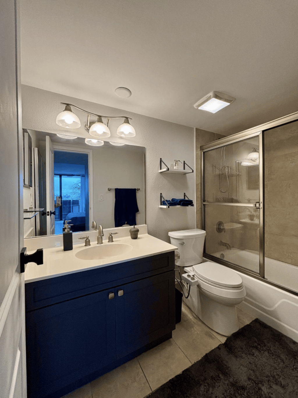 The bathroom is just off the bedroom, with a tub, shower and bathroom essentials.