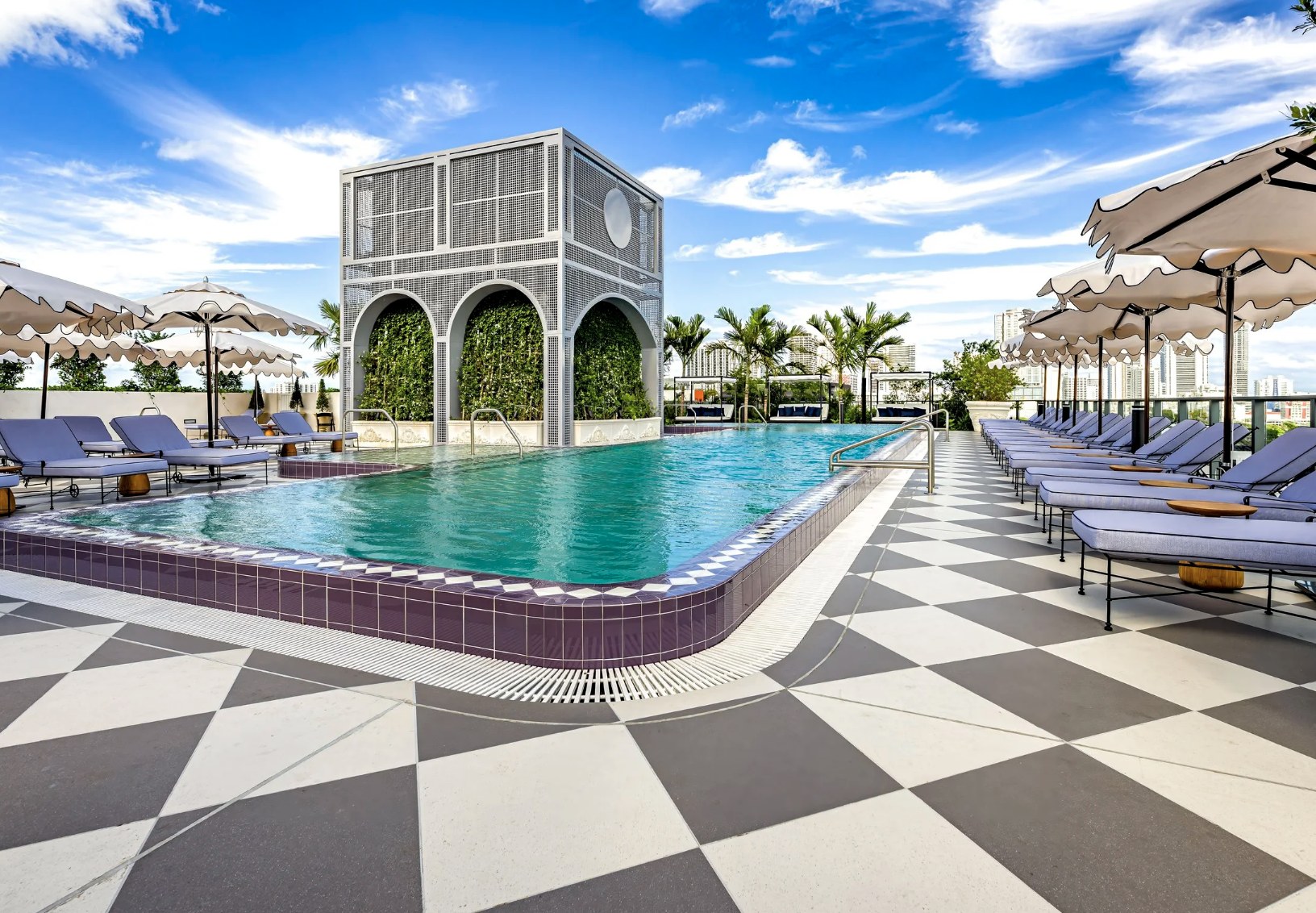 Rooftop pool deck — loungers, white umbrellas and signature arched cabana