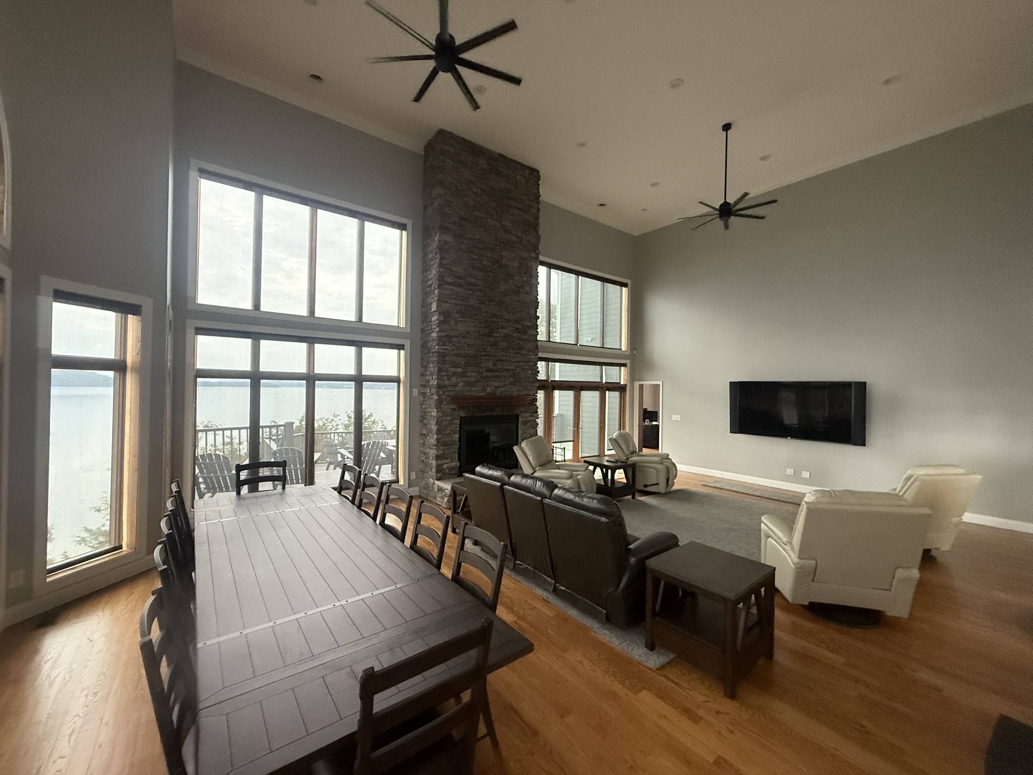 A large dining table comfortably seats 12 people, featuring very cozy, cushioned seats.  Equipped with 75 x 43 inch Theatre room-style top quality TV