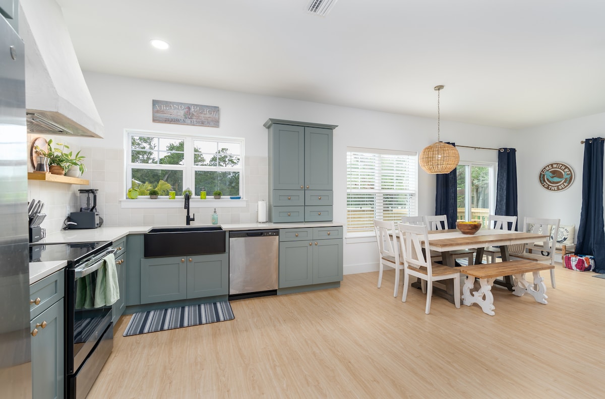 Sage cabinets, a deep farmhouse sink, and a window above it that catches the morning. Guests keep telling us the kitchen has everything they need, which is the point - half the best meals here never leave the house.