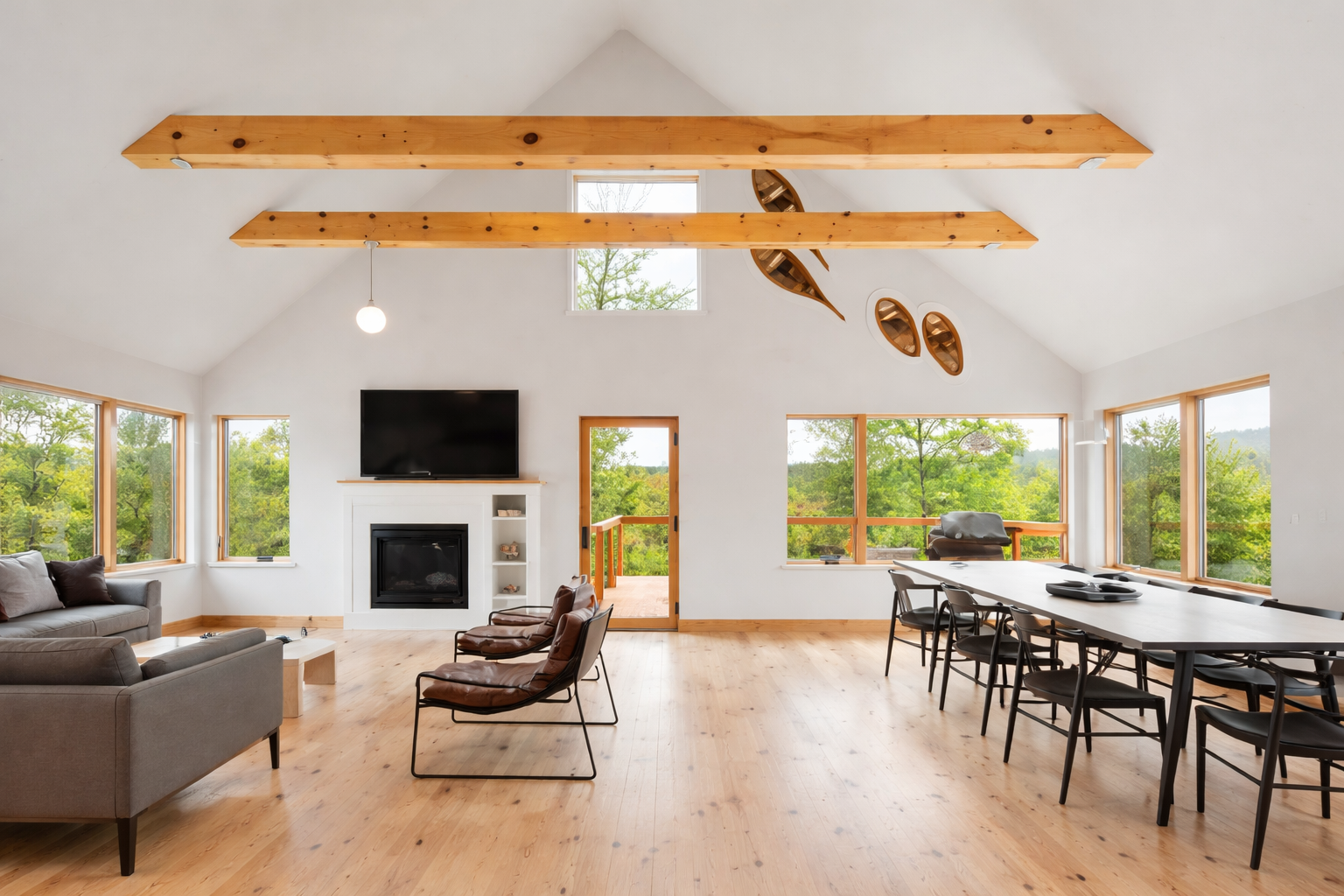 Gorgeous cathedral ceilings an d natural wood exposed beams in living room with easy access to second level deck.