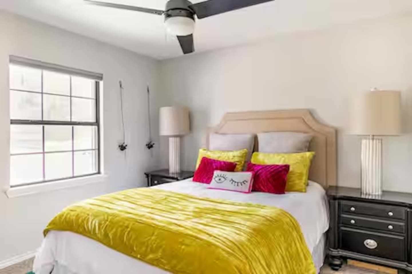 Bedroom with queen bed and colorful accent pillows.