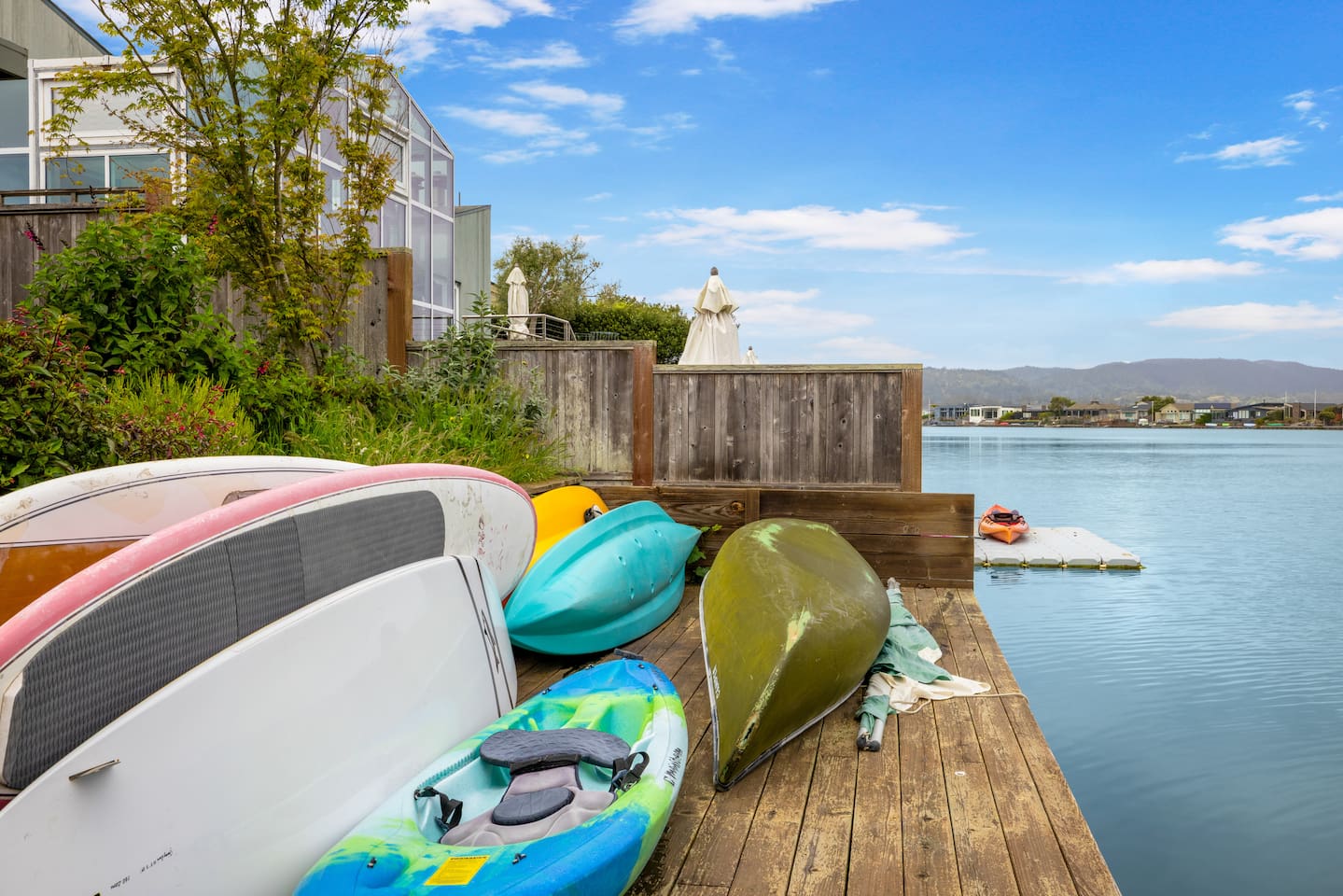 Dock with kayaks, paddleboards, and canoes ready for use.

