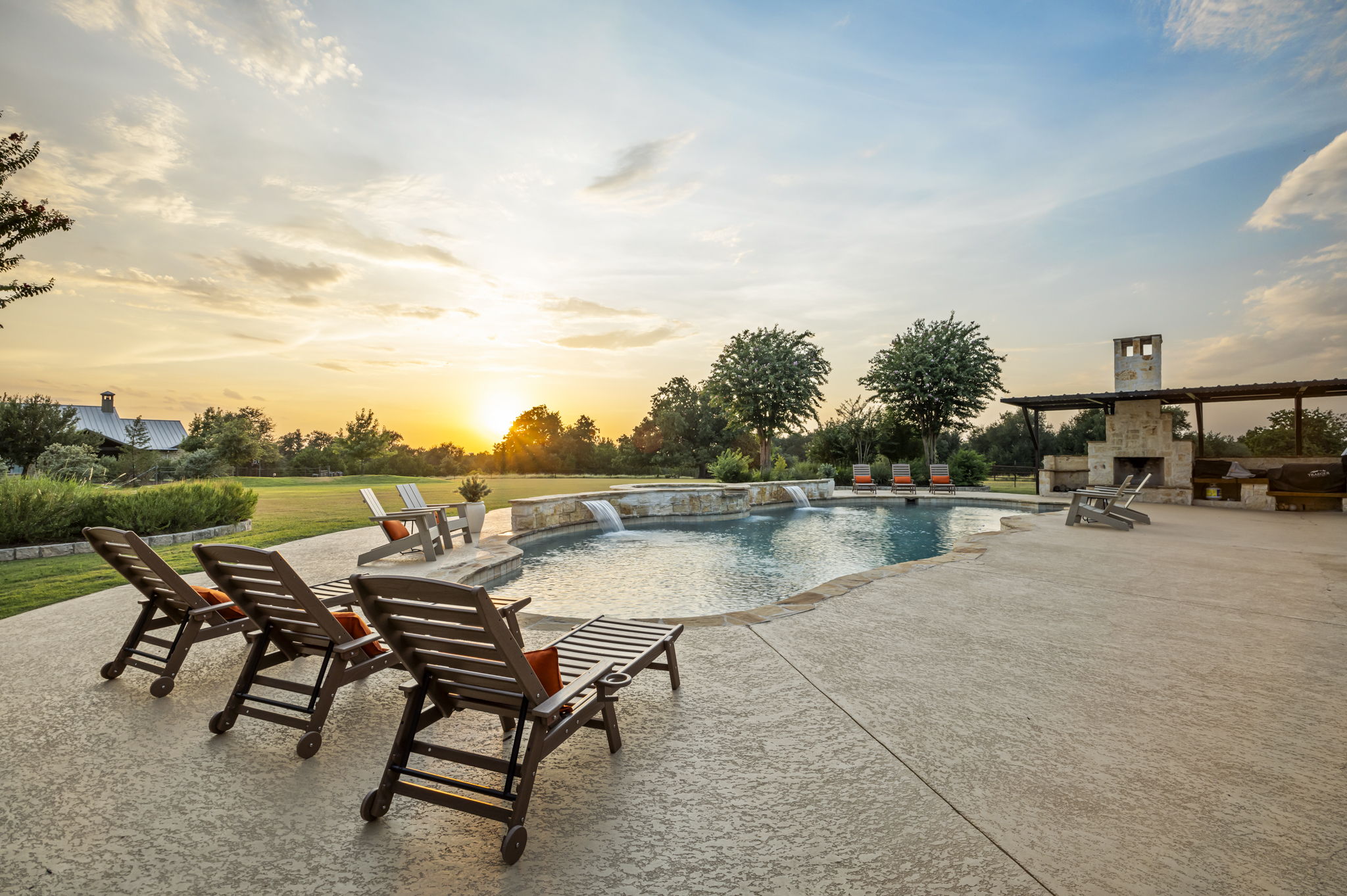 Lounge chairs line the edge of a resort-style pool.