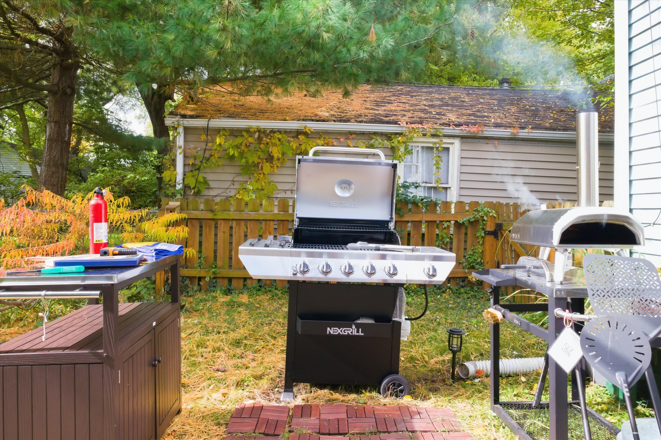 Grill, prep, and fire up flavor—our South Bend guest retreat features a 5-burner propane grill, backyard pizza oven, and prep table for alfresco meals and family-friendly fun near Notre Dame.