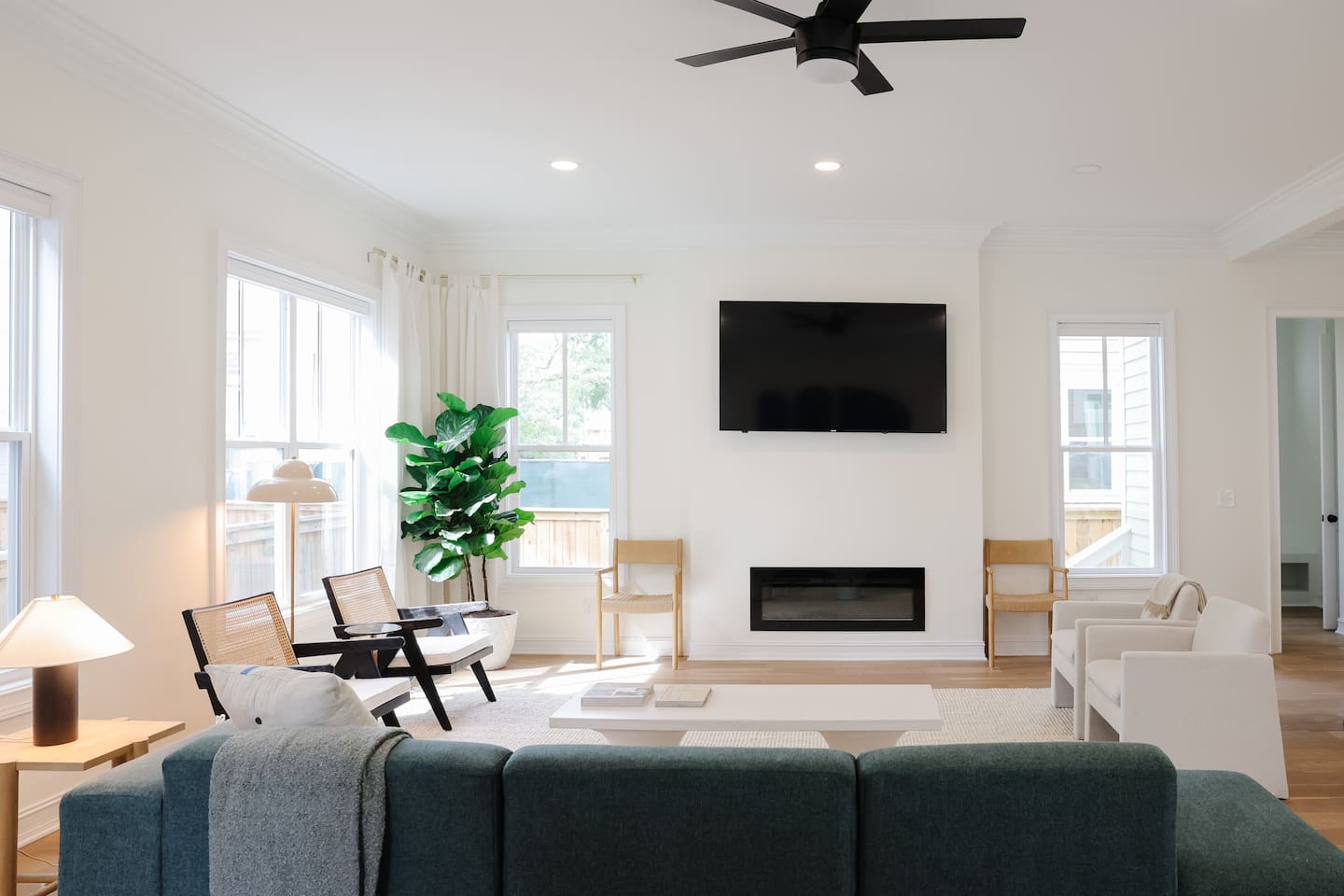 The light-filled living room features an oversized Floyd couch, a 70" smart TV and an open floor plan that flows seamlessly into the kitchen and dining areas. Great spot for hanging with a large group.