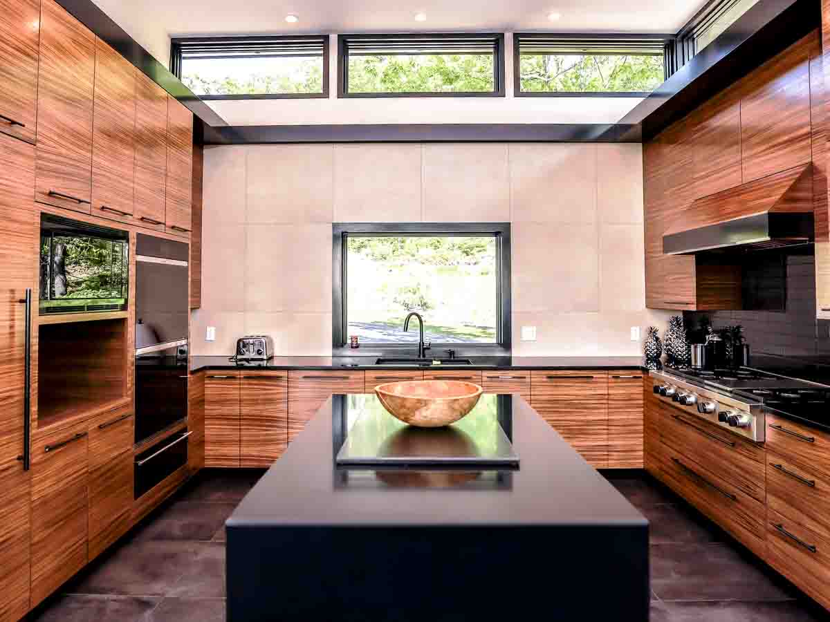 The Chef&rsquo;s Kitchen at Sunset Falls &mdash; zebrawood cabinetry, black quartz, Wolf range, valley view through window