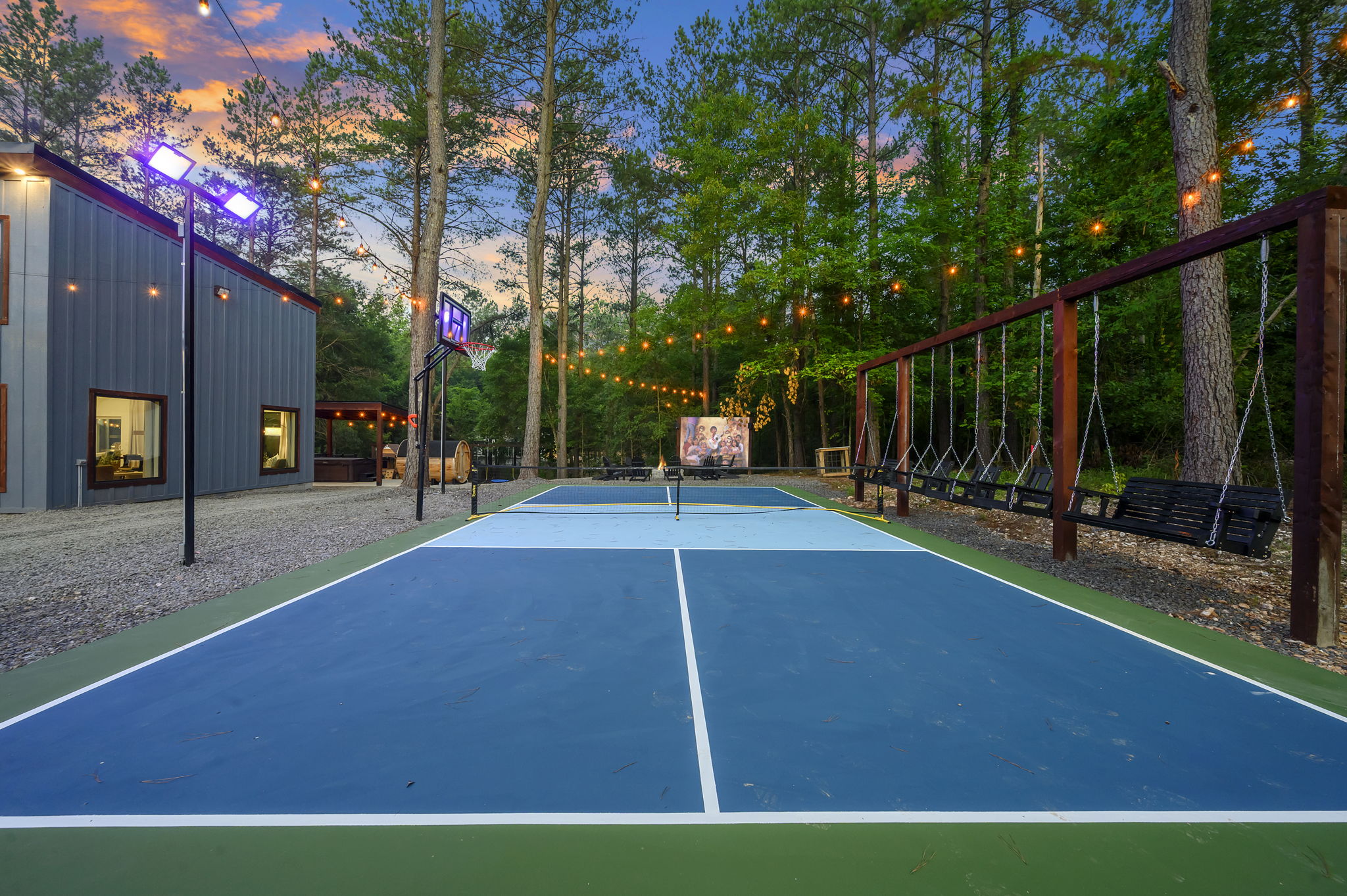 Your own pickleball + basketball court under the pines, with swings for the cheering section. When the games end, gather by the fire pit for an outdoor movie under the stars.
