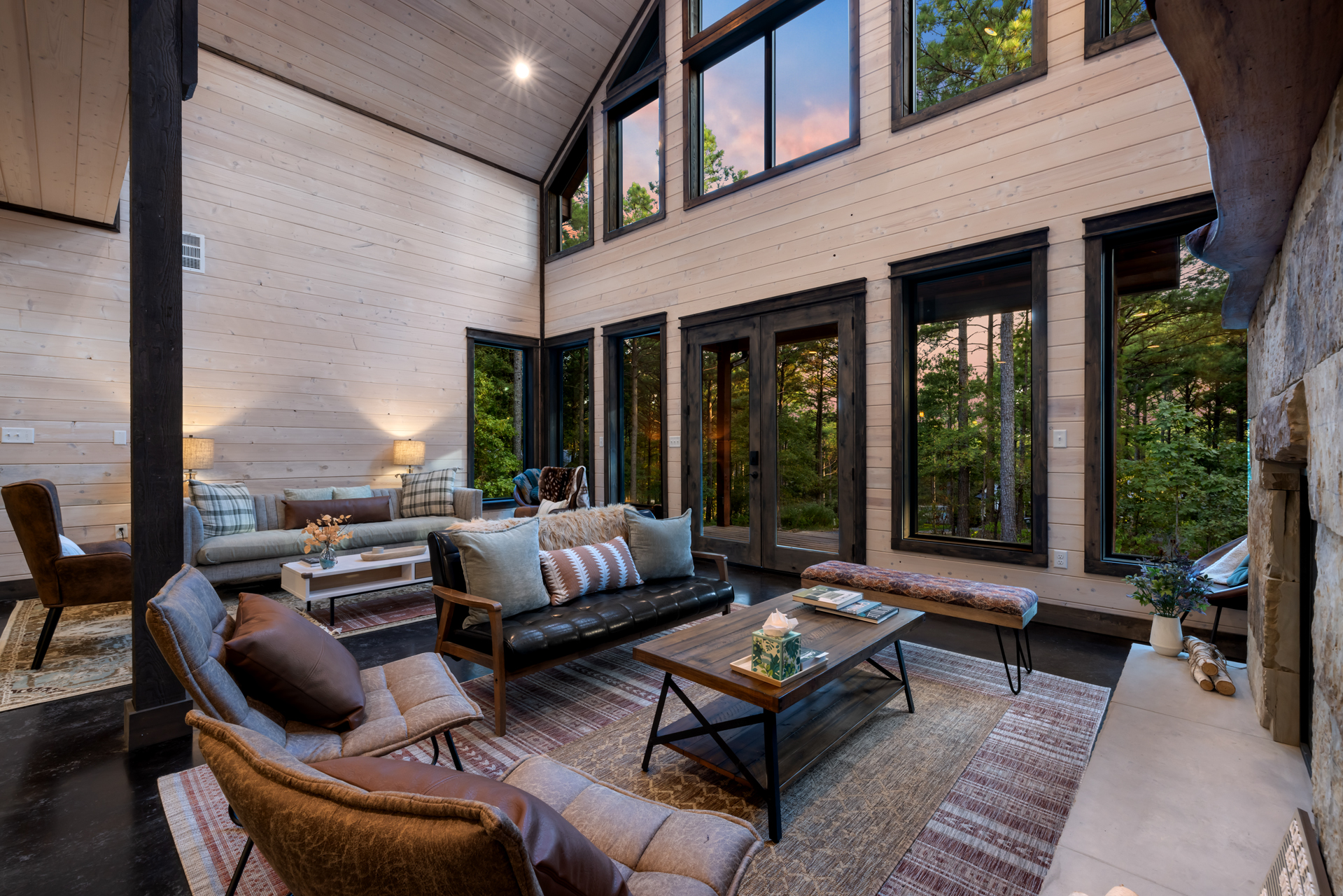 Spacious living room with two sofa sets—one facing the TV and indoor fireplace for cozy movie nights, and a second set behind for extra seating and easy group gatherings in a warm, open layout.