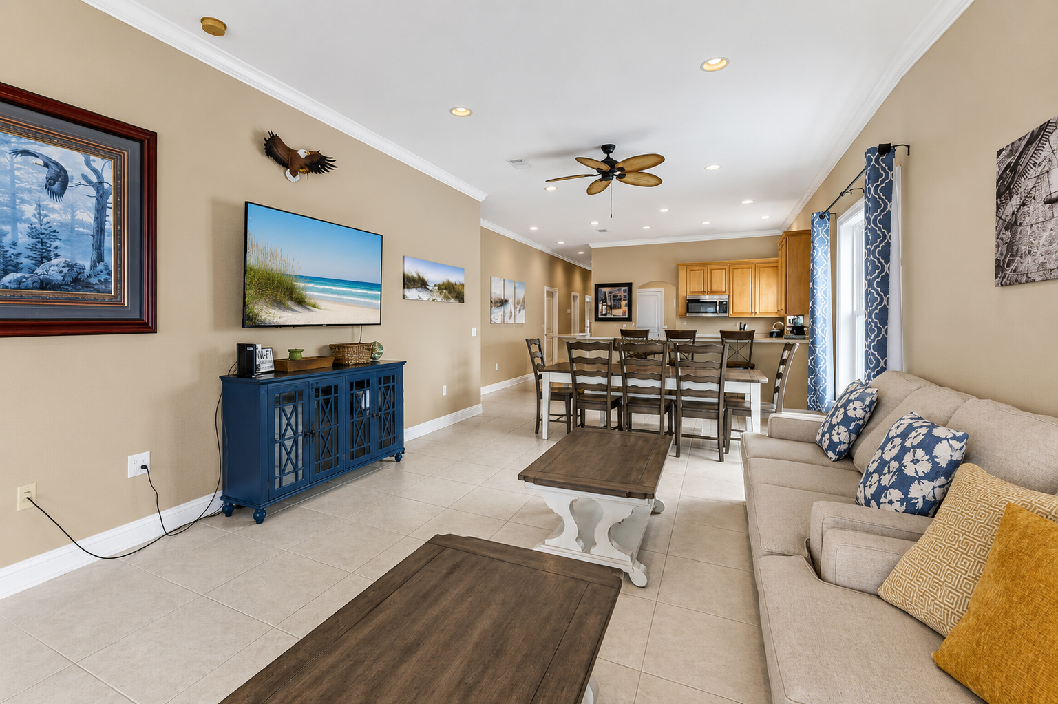 Great room flowing into the dining area and kitchen, anchored by a wall-mounted smart TV