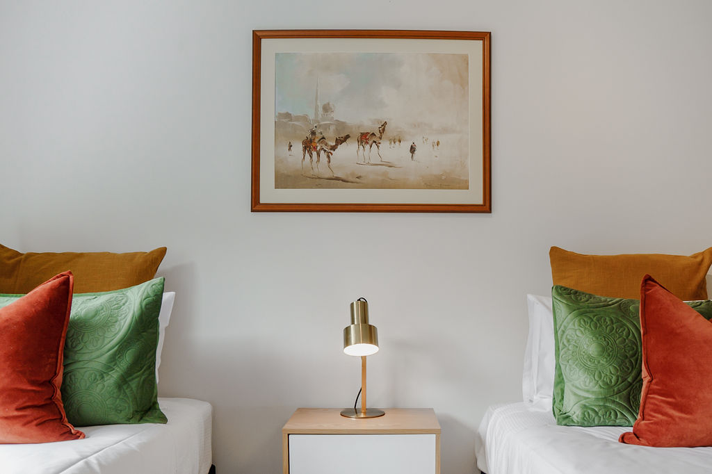 Twin beds, individual pillows and a central bedside lamp give this bedroom a practical, well-set sleeping setup at Fernhill Mountain Escape.