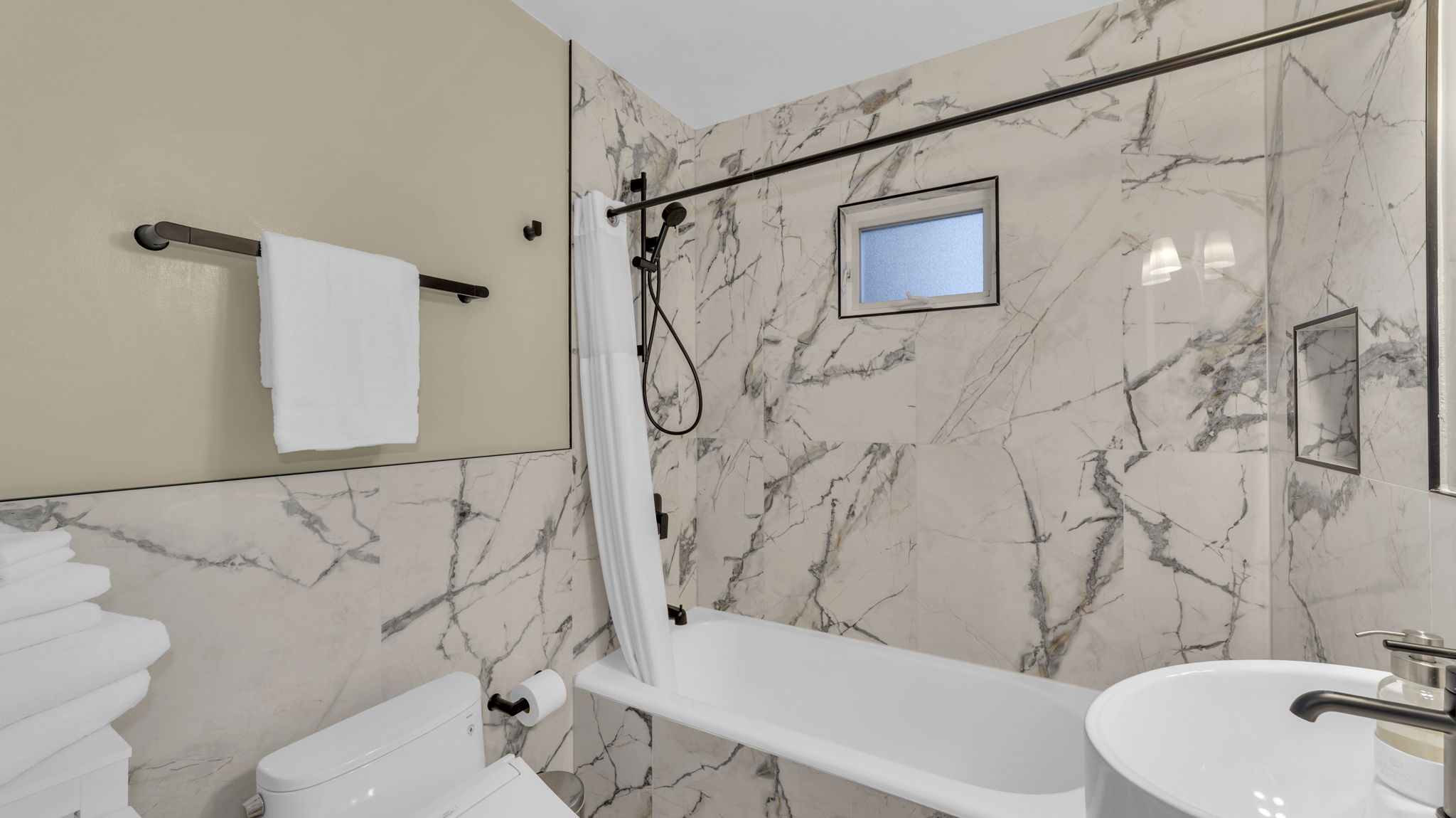 Unwind in this spa-inspired bathroom, complete with a deep soaking tub, rain shower, and elegant marble finishes