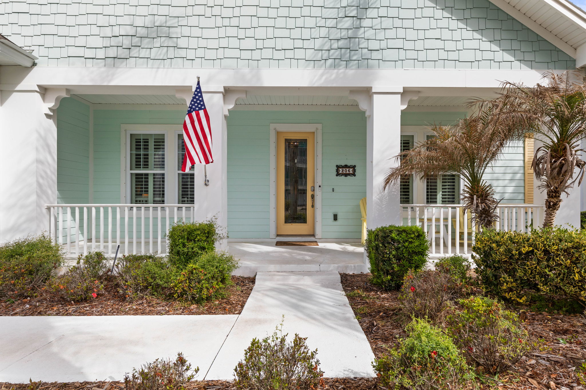 Follow the path to a breezy coastal welcome, where yellow porch rockers invite slow mornings, the pastel exterior sets the mood, and the first step to the door feels like the start of the easy beach getaway you’ve been needing.