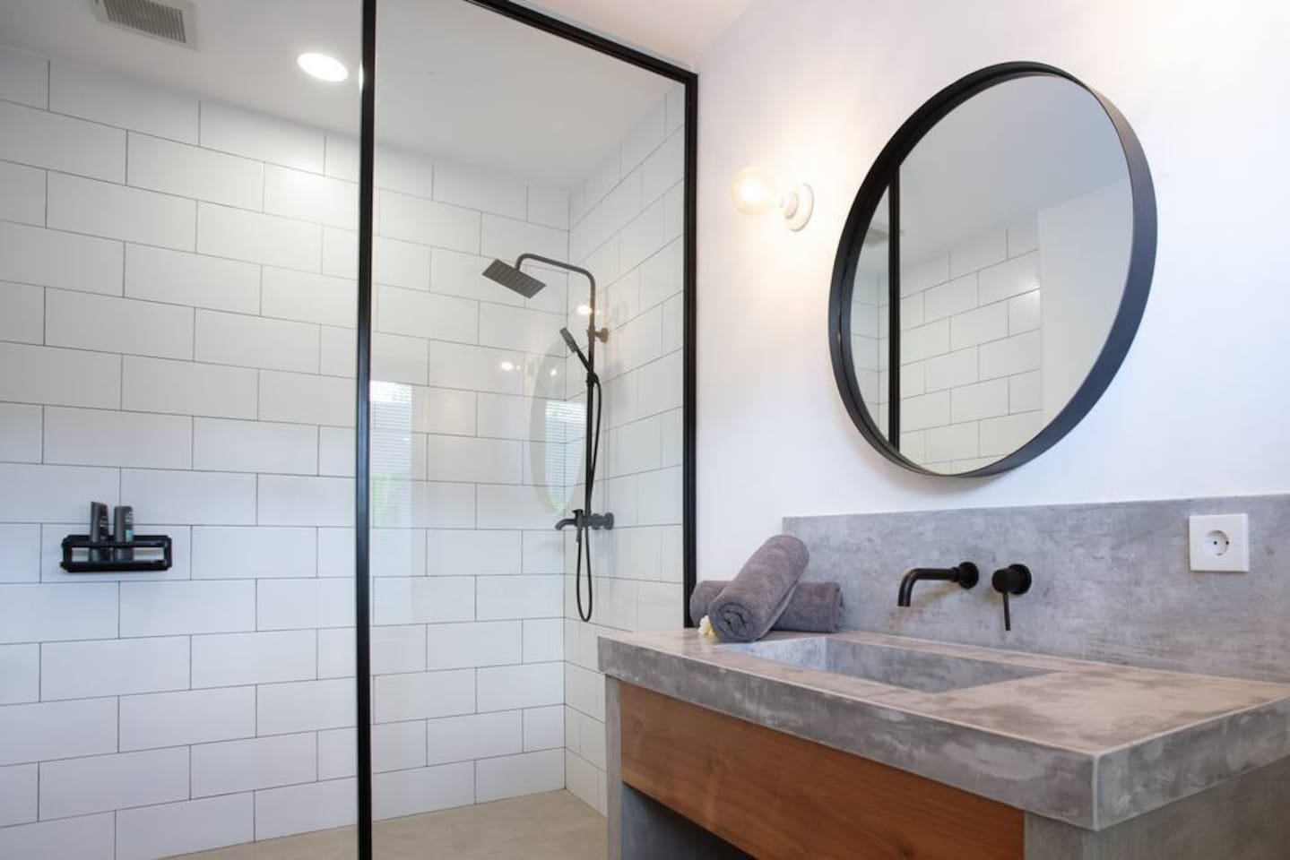 A spacious bathroom featuring a shower, a toilet with bidet, and a sink. A hairdryer is provided for your comfort.