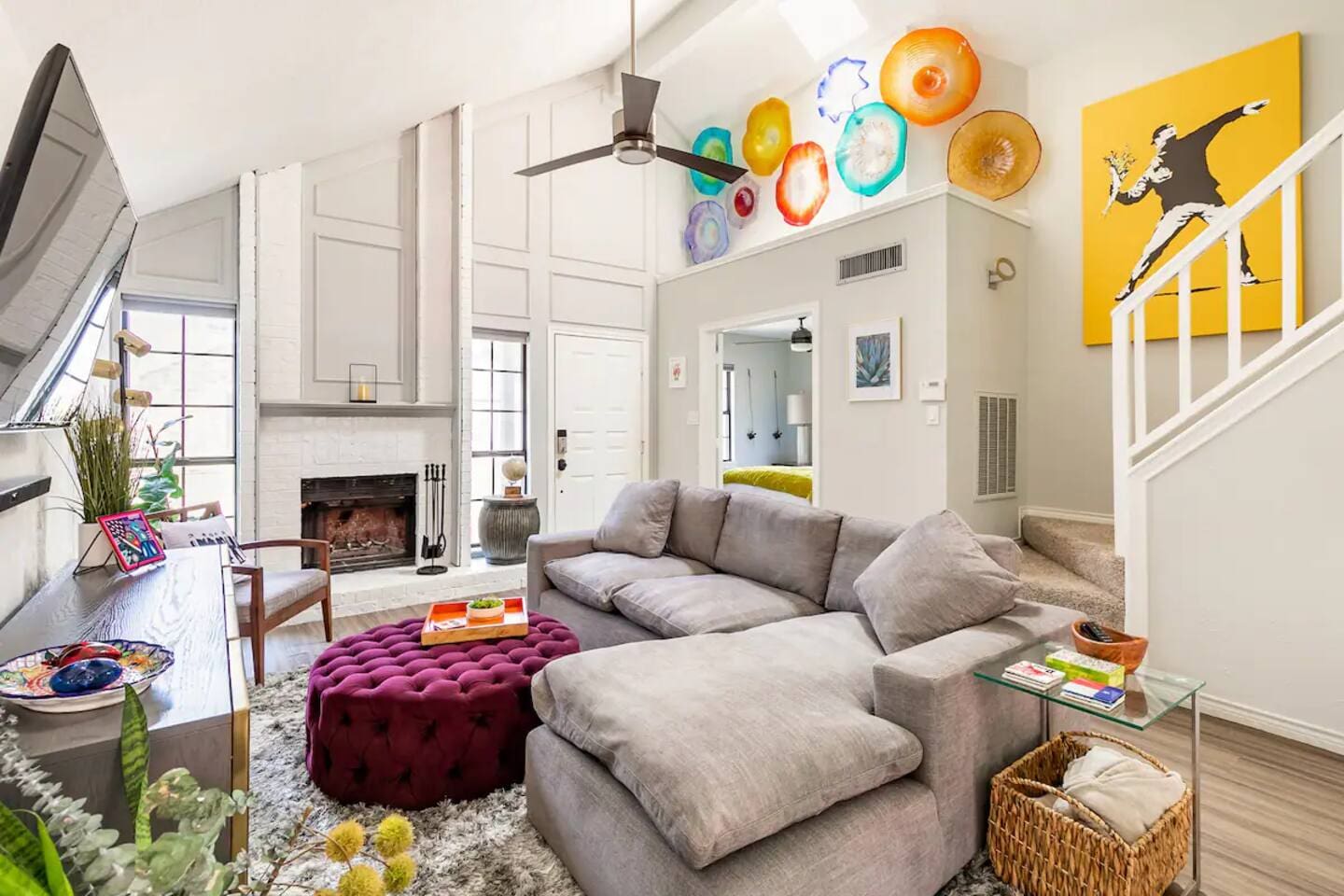 Bright living room with sectional sofa, colorful accents, and natural light.