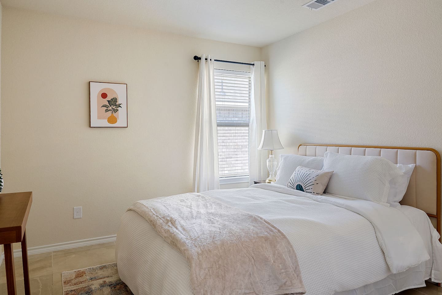 Discover a charming bedroom adorned with tasteful wall art and a bedside lamp that enhances the cozy atmosphere.