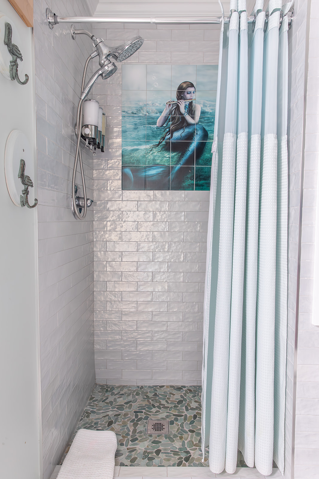 Step into the walk-in tile shower, where a mermaid adds a bit of coastal character to your routine. With a gentle shower head and bulk shampoo, conditioner, and body wash provided, it’s an easy place to wash away the day and unwind.