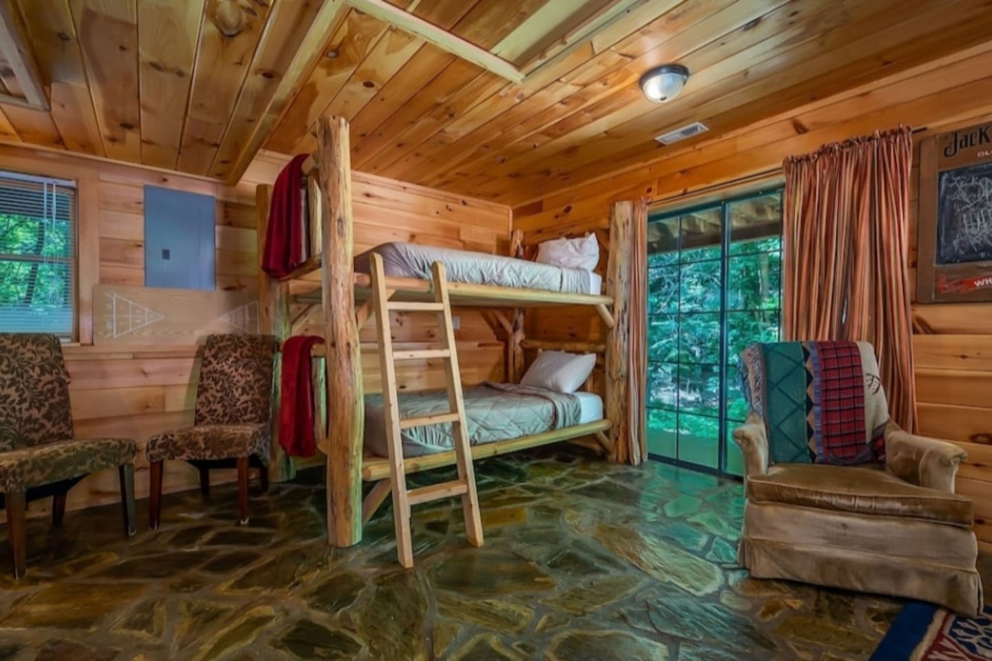 bedroom three with 2 sets of log bunks, full bathroom, game room and French doors to lower deck, Hot Tub and private back yard.