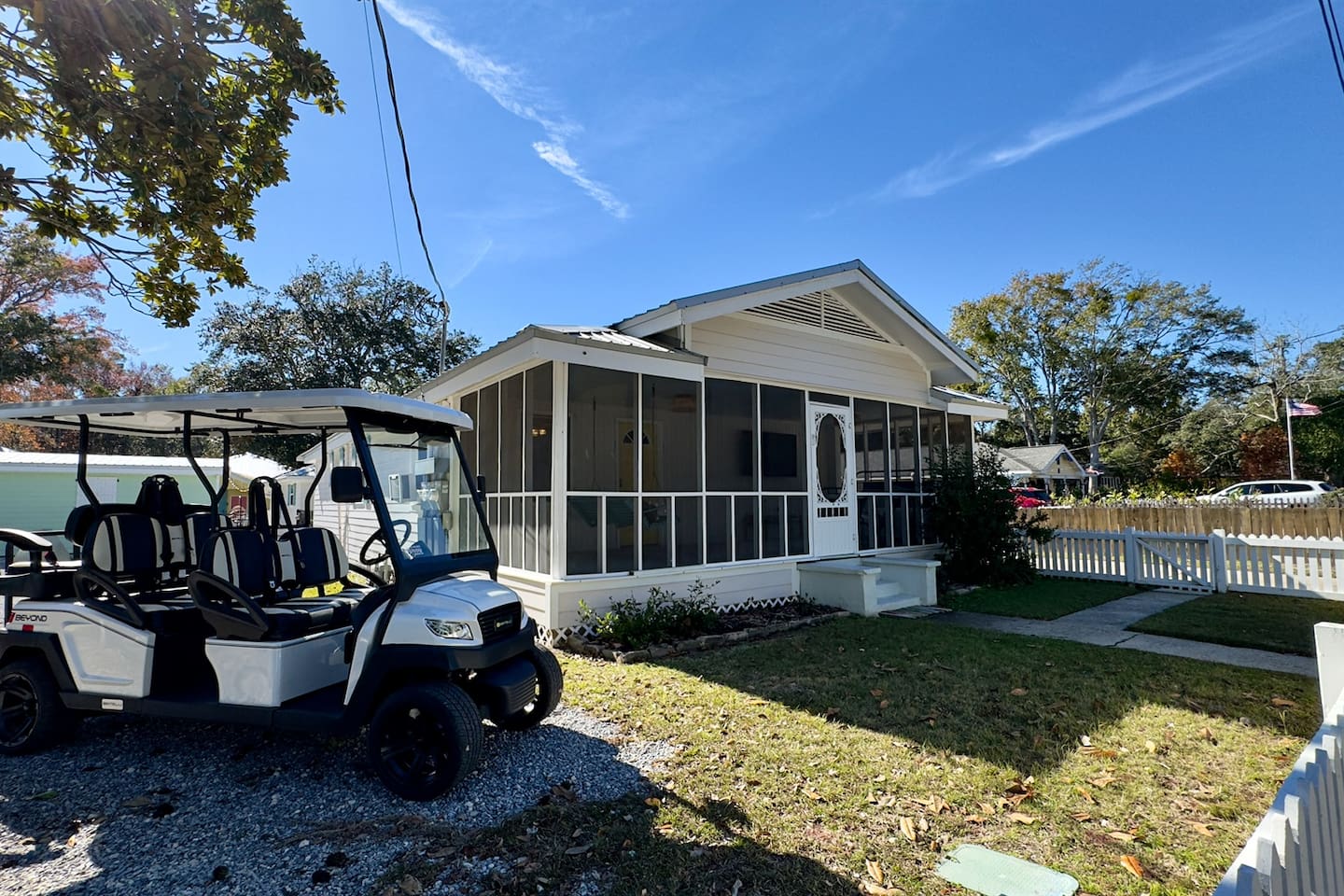 Charming cottage exterior with a screened porch, private yard, and convenient golf cart access.