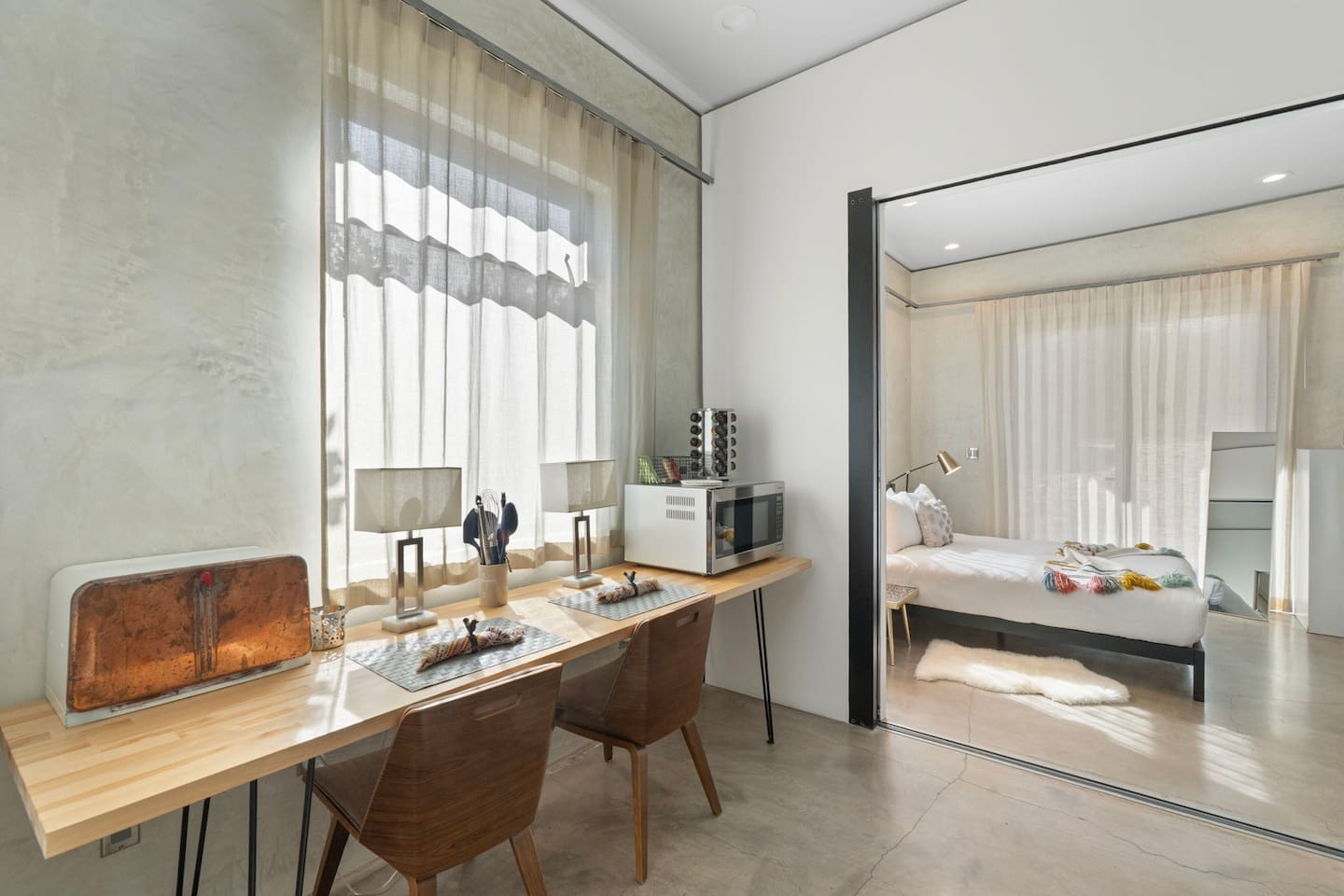 Bright workspace area with dual seating, natural light, and direct access to the bedroom.