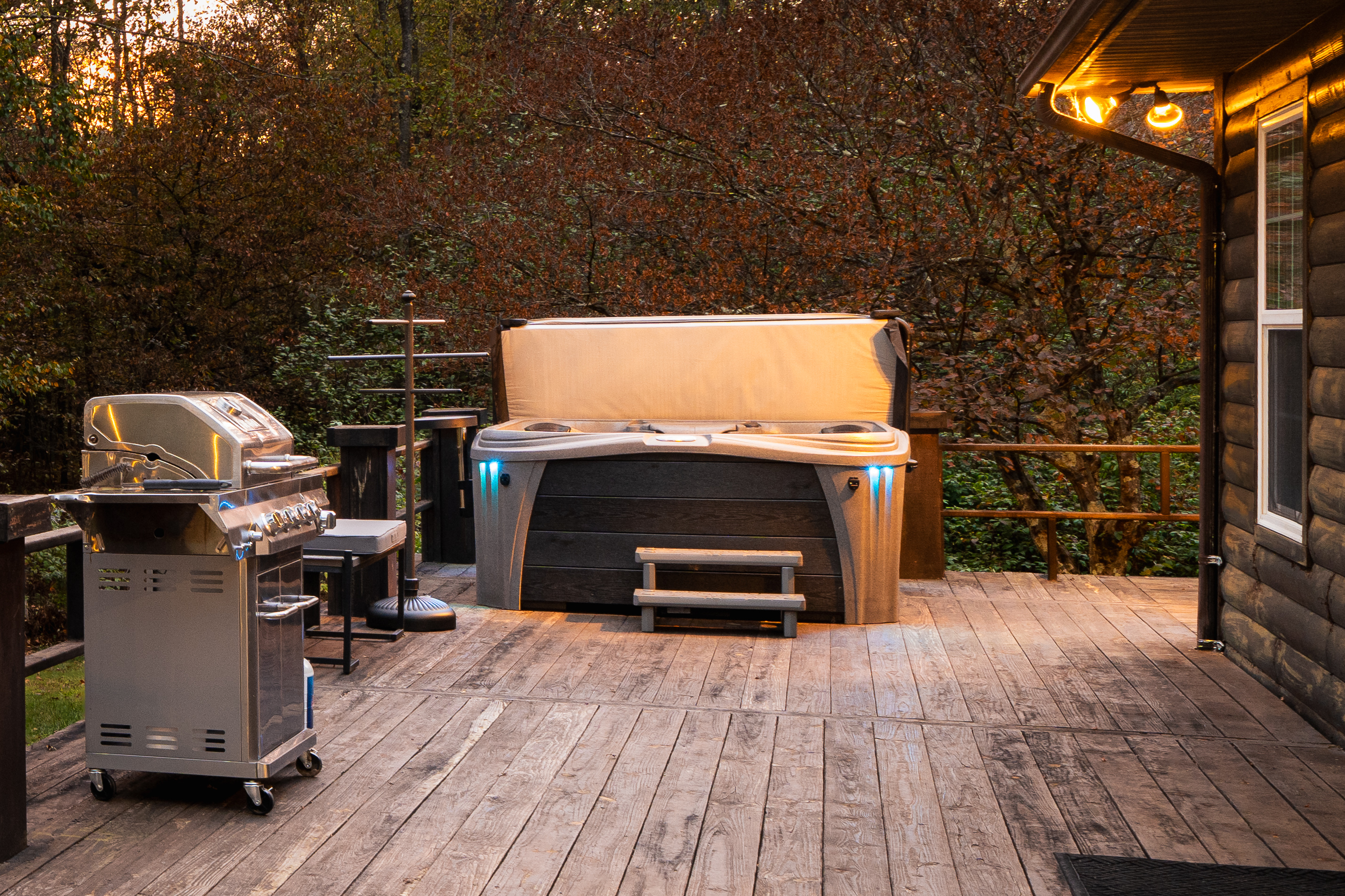 Private hot tub nestled in the trees on the back deck — unwind under the stars after a day exploring the 75+ acres at Runway Retreat