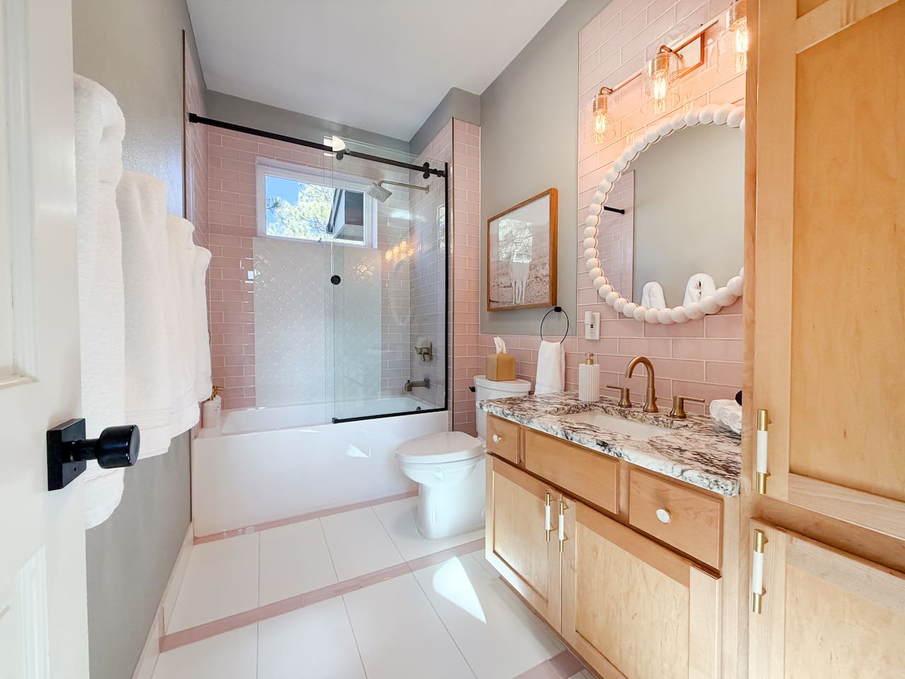Bright and charming custom bathroom with tub, shower, plush towels, and thoughtful touches for a cozy, inviting experience.
