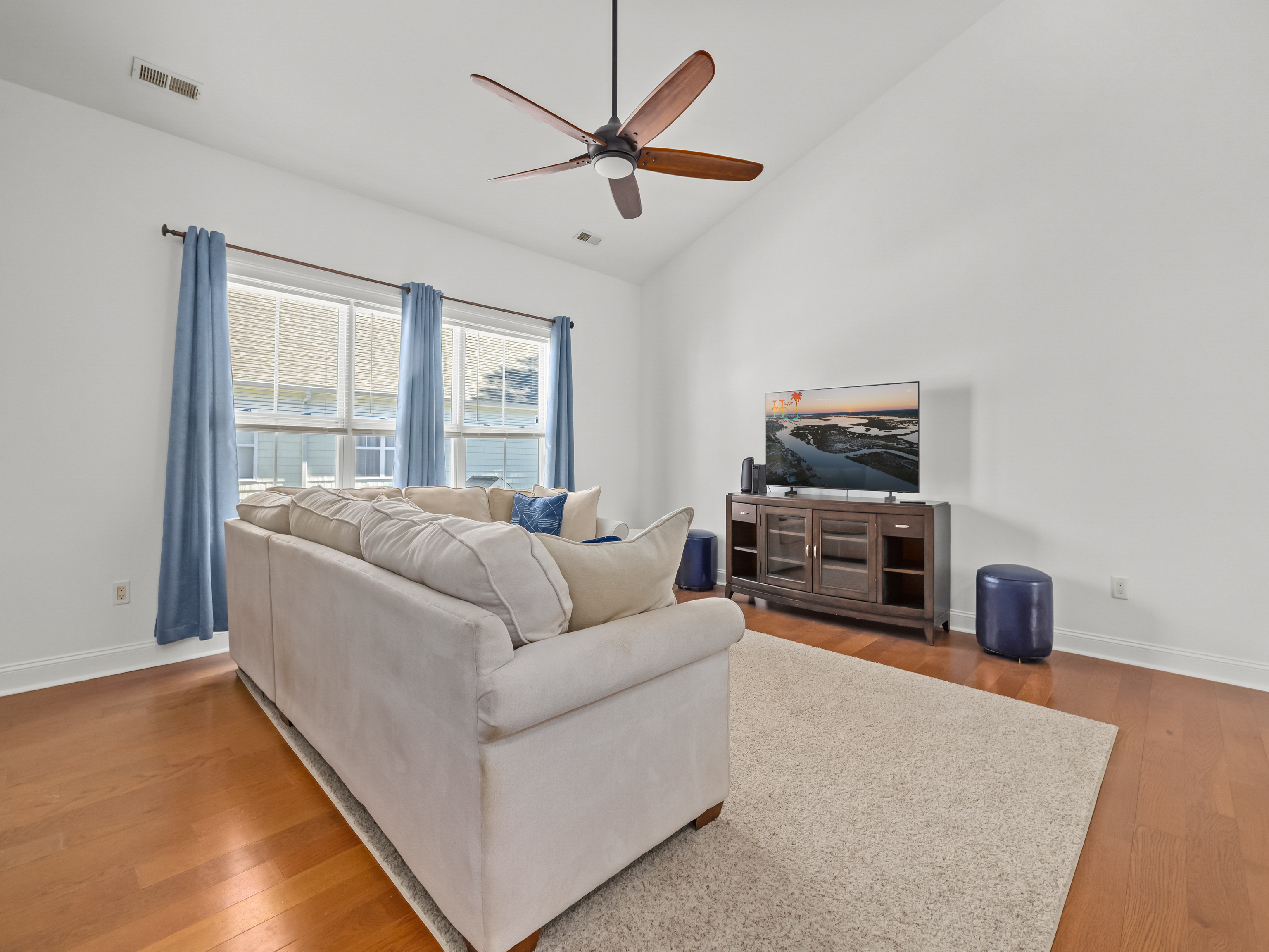 This airy, oversized living space is made for family movie nights, morning cartoons, afternoon naps, and late-night laughs. Vaulted ceilings and soft coastal light create a relaxed, open feel, while the generous sectional invites the whole crew to settle i