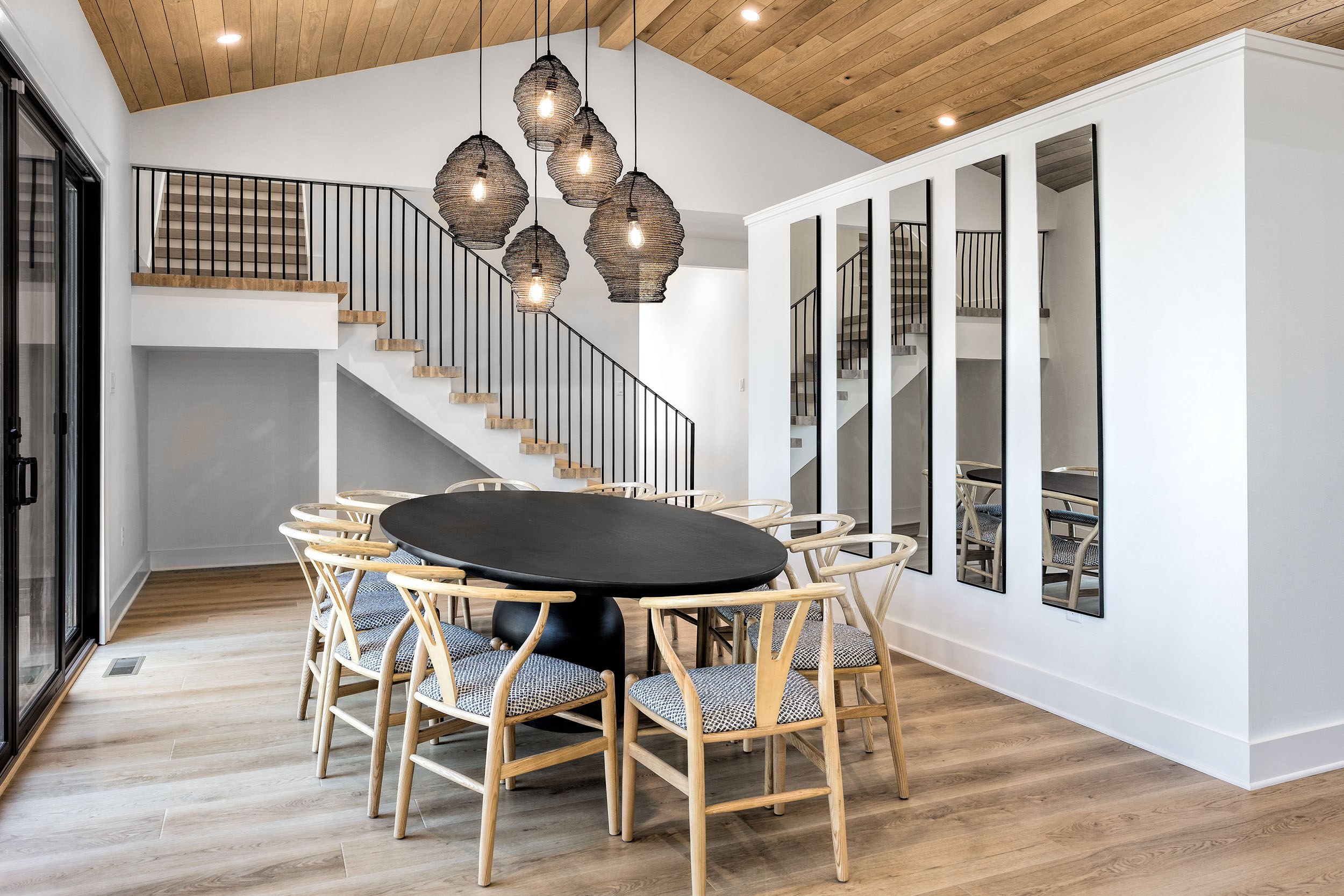 Gather your group around the large dining table with views of the outdoor deck and woods beyond—perfect for shared meals and memories.