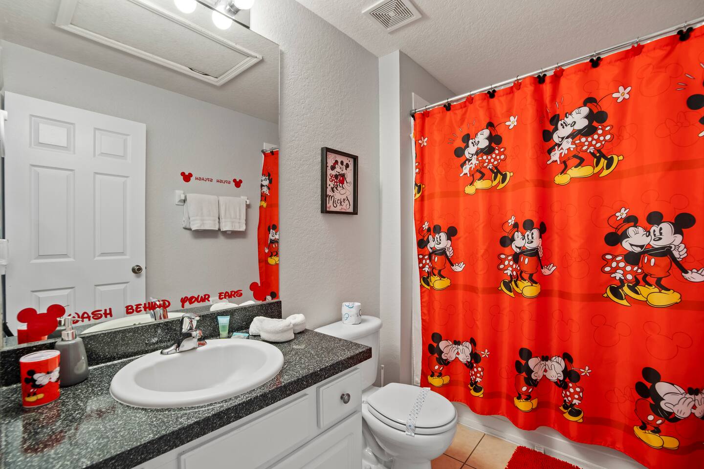 - Bright bathroom with bold red Mickey and Minnie shower curtain for flair  
- Granite vanity, large mirror, and playful Disney accents throughout  
- Perfect for adding fun and color to daily routines during your stay  
