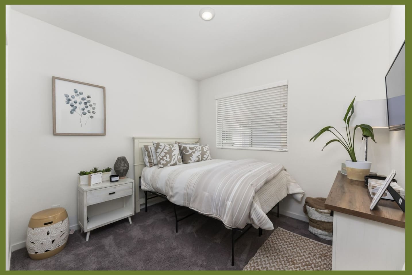 Guest bedroom with a comfortable queen bed, wall-mounted TV, nightstand, and a clean setup for a restful stay.
