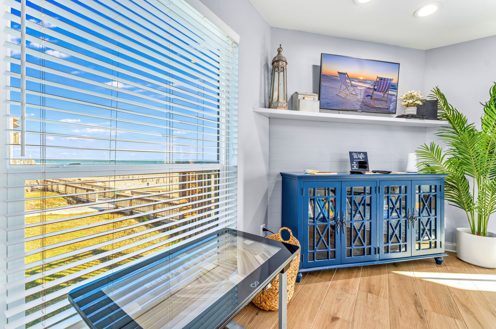 The living room at Seascape features an Infiniti game table, perfect for entertainment and relaxation. Additionally, there is a selection of board games available on the bookshelf and inside the blue cabinet, ensuring plenty of fun options for guests.