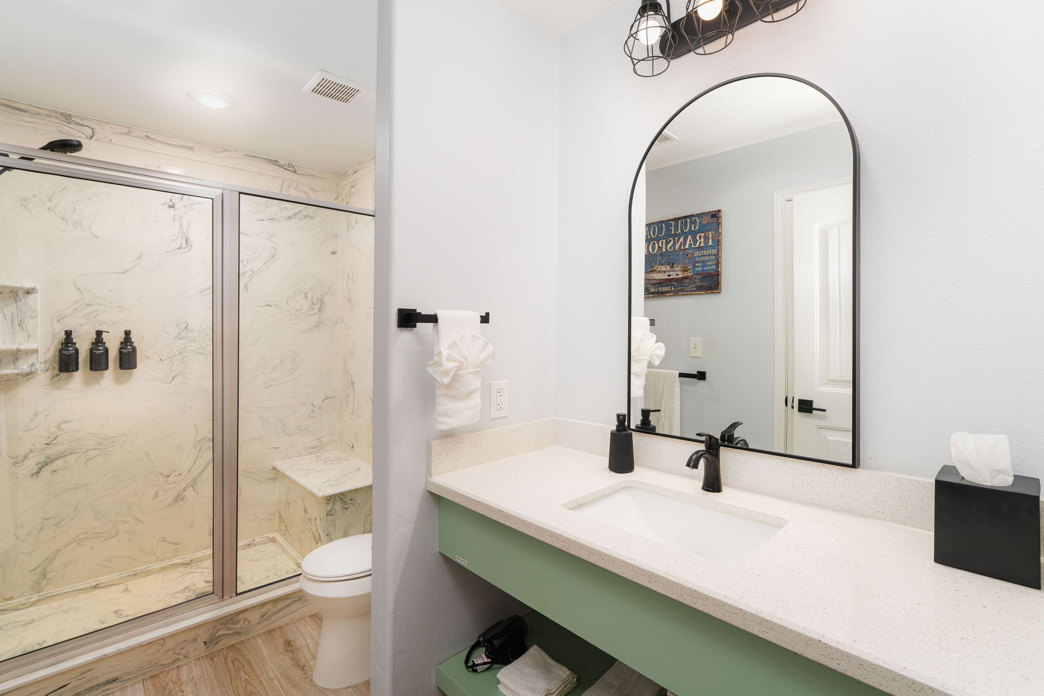 Titanic ensuite bath — marble-look shower, green vanity. Private to the main-floor King suite.
